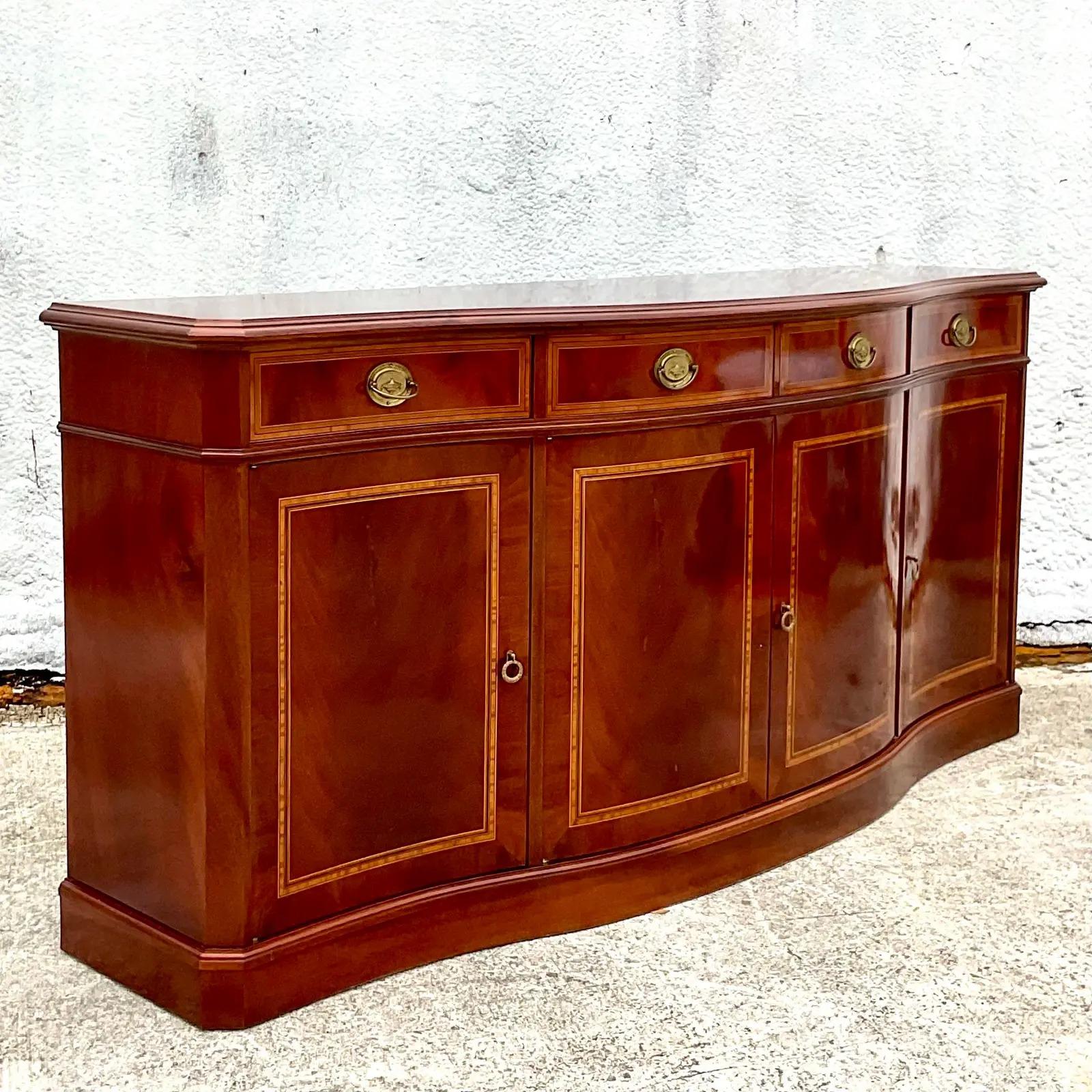 A gorgeous vintage Regency credenza. Beautiful flame mahogany with hand laid inlay detail. Lots of great storage below. Each door handle is a key. Acquired from a Palm Beach estate.