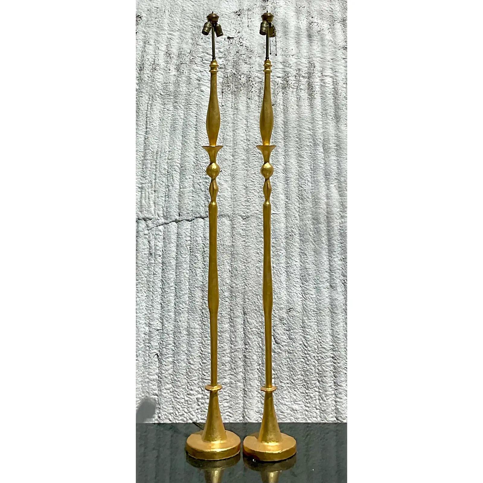 A striking pair of vintage Regency floor lamps. Made by the iconic Frances Elkin. After the classic Giacometti design. Painted a bright gold. Acquired from a Palm Beach estate.

The lamps are in great vintage condition. Minor scuffs and blemishes