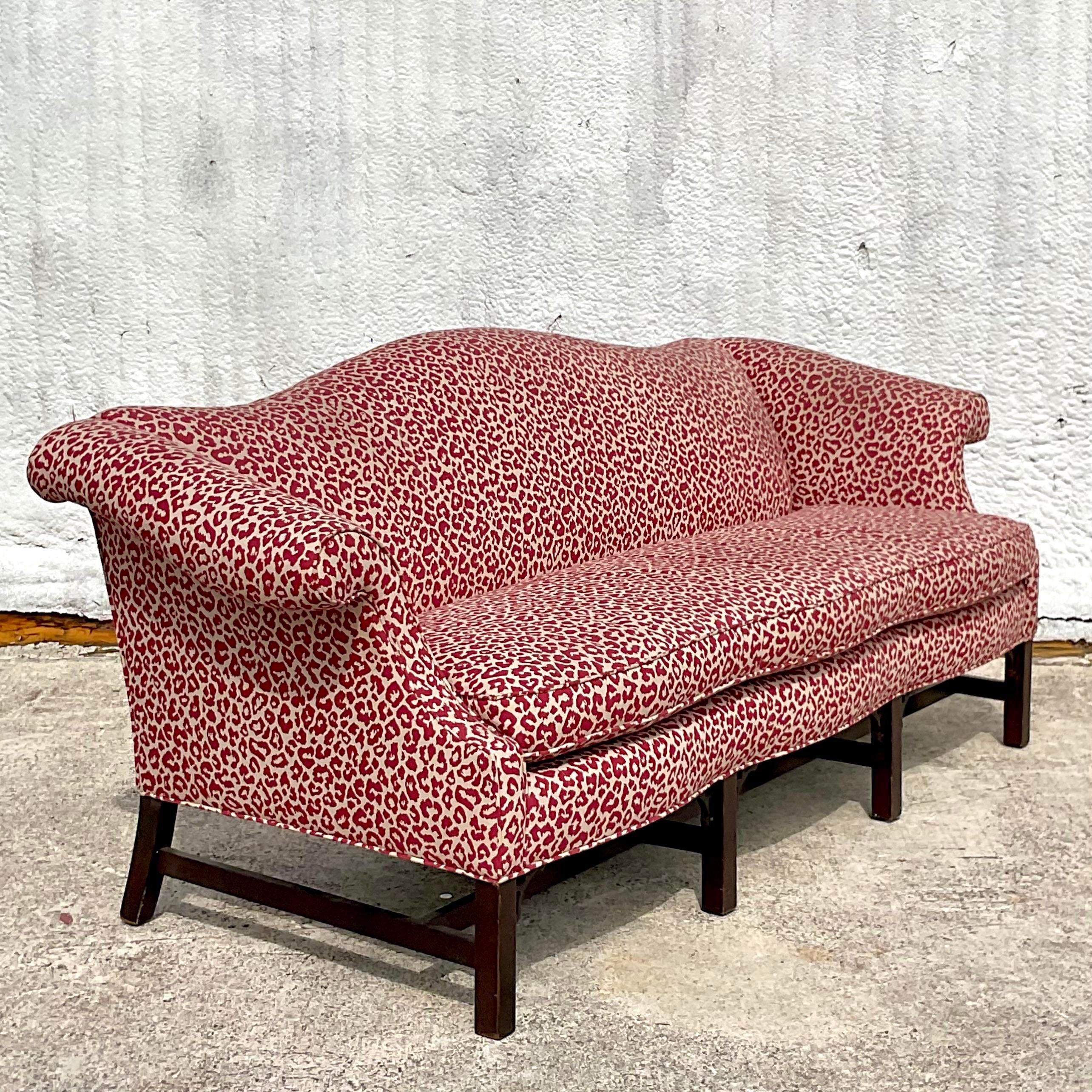 A fantastic vintage Boho camelback sofa. A chic leopard jacquard with beautiful fretwork detail along the wooden frame. Acquired from a Palm Beach estate.
