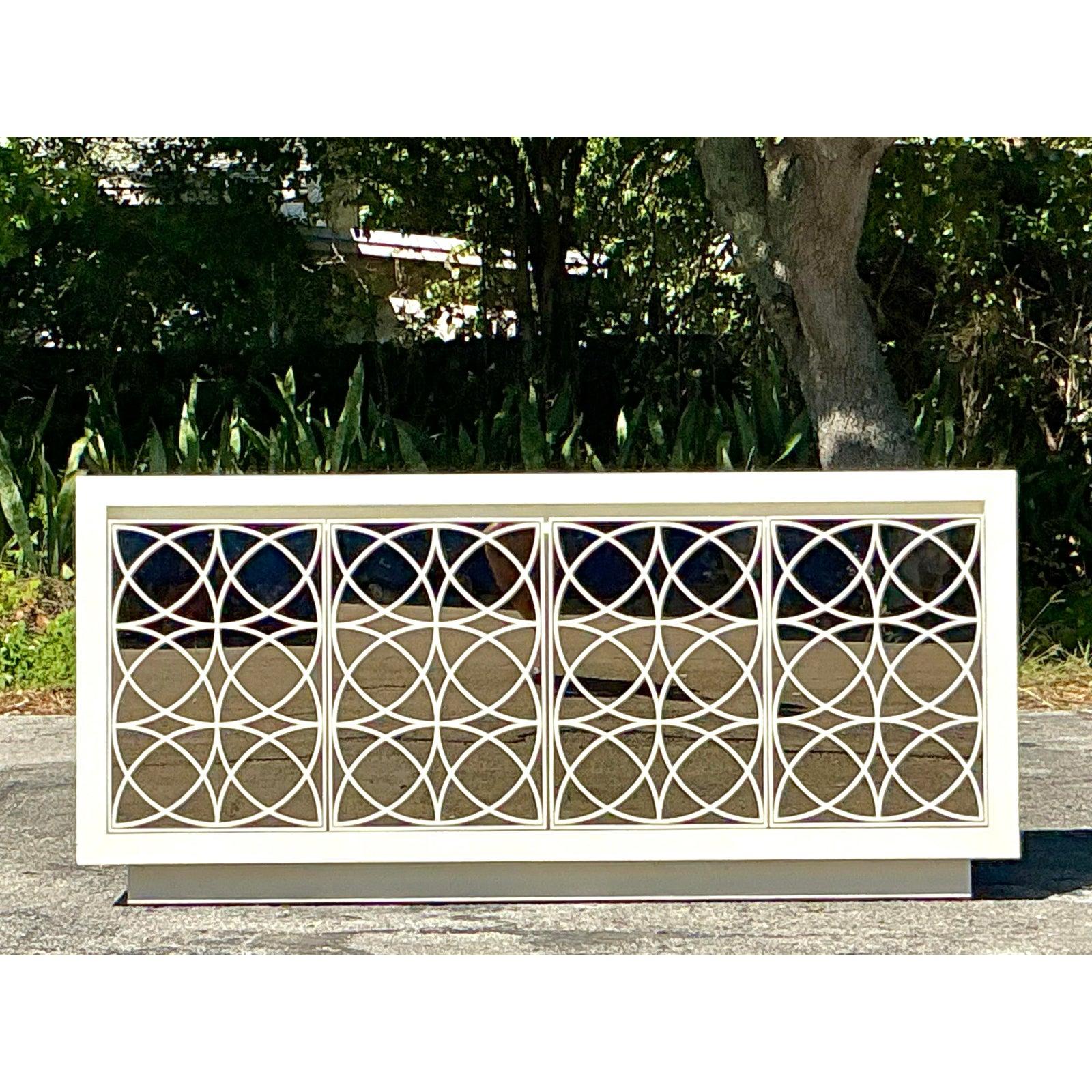 La elegancia se une a la funcionalidad en este impresionante aparador vintage de estilo Regencia. Con un llamativo frente de espejo con intrincados detalles calados, esta pieza irradia sofisticación clásica y encanto refinado. El nítido acabado