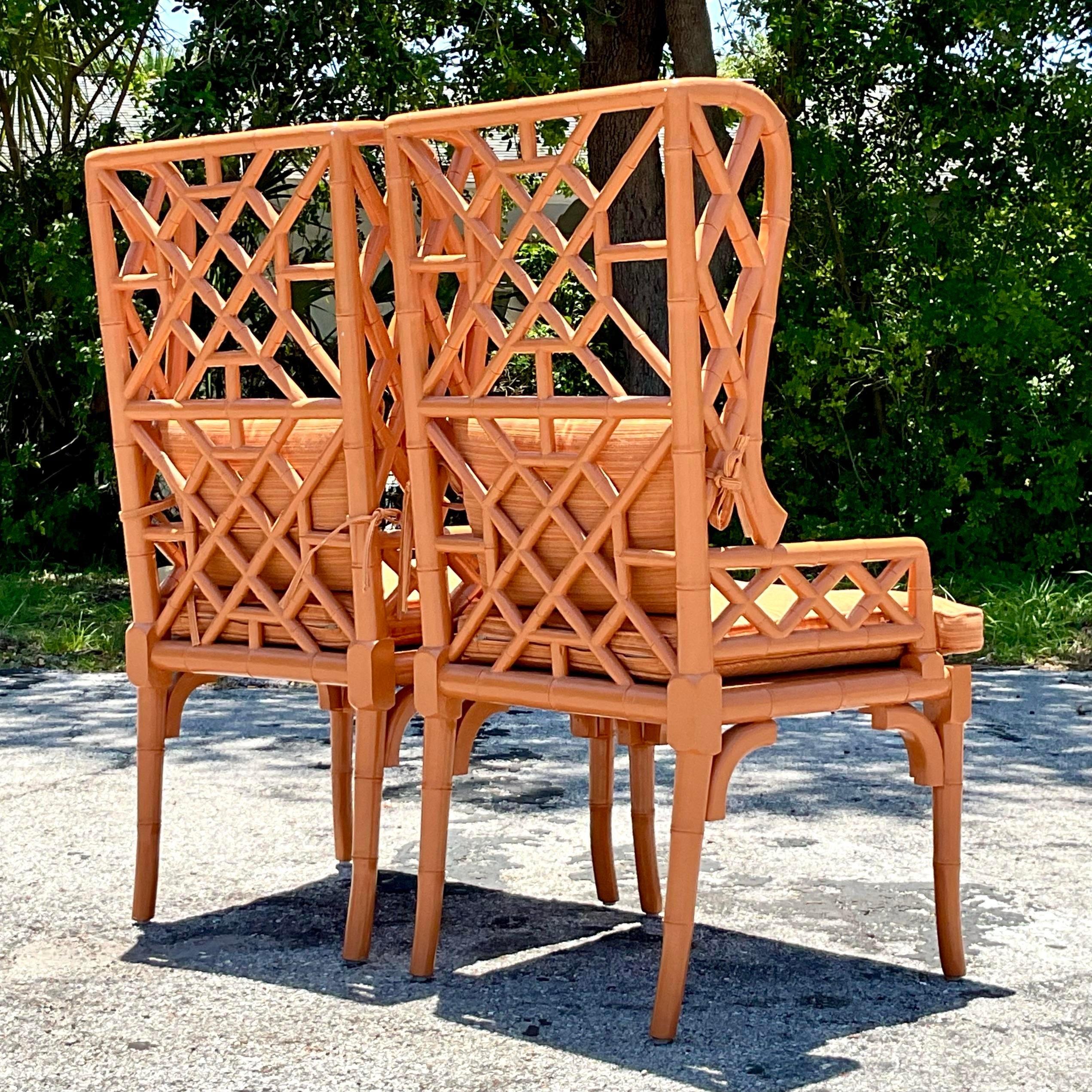 The Vintage Regency Fretwork Wingback Chairs - A Pair epitomize American style with their classic Regency design and intricate fretwork detailing. These elegant wingback chairs add a touch of timeless sophistication and vintage charm to any living