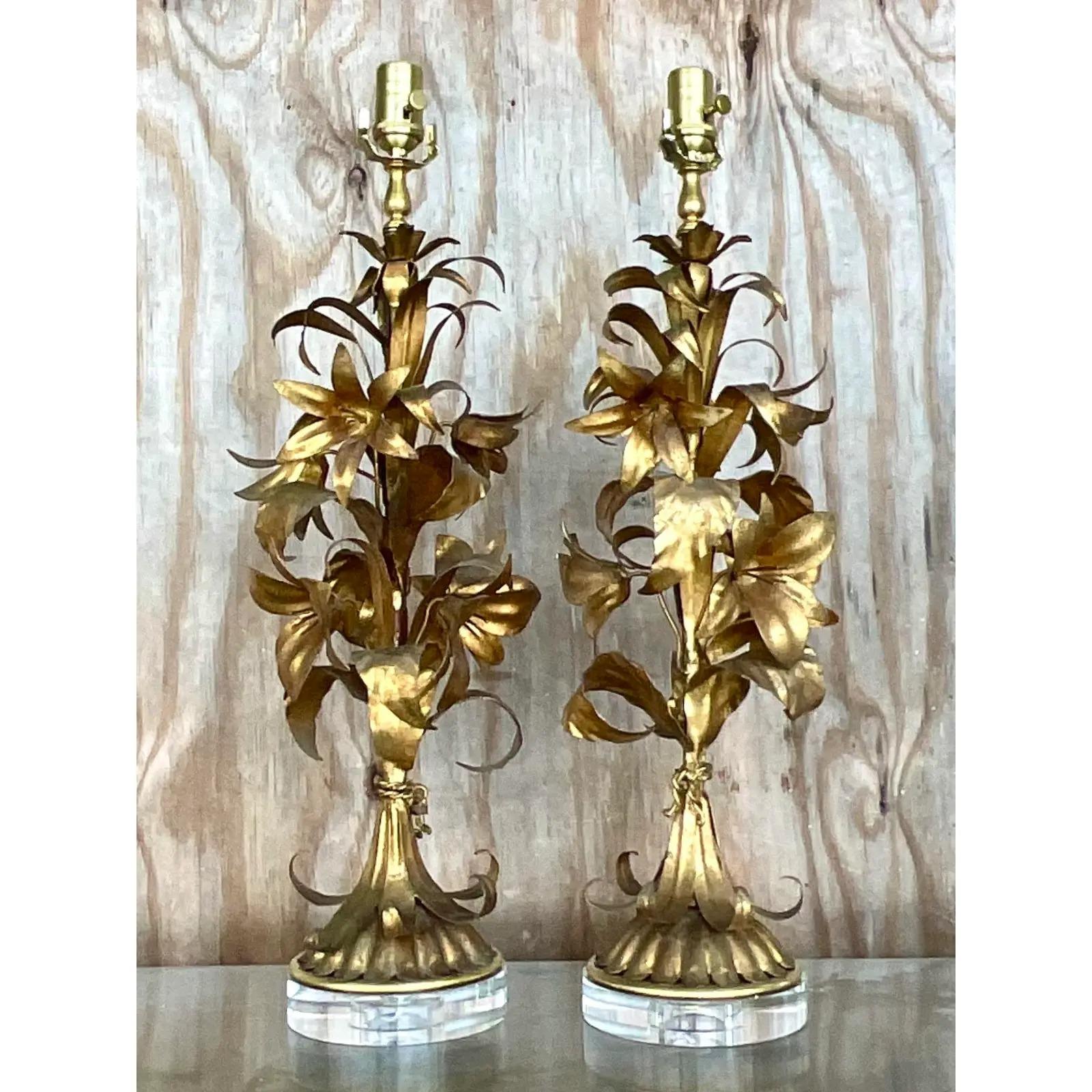 A fabulous pair of vintage Regency table lamps. A chic gilt lily design on contemporary lucite plinths. A fresh interpretation of a Palm Beach classic. All new wiring and hardware. Acquired from a Palm Beach estate.