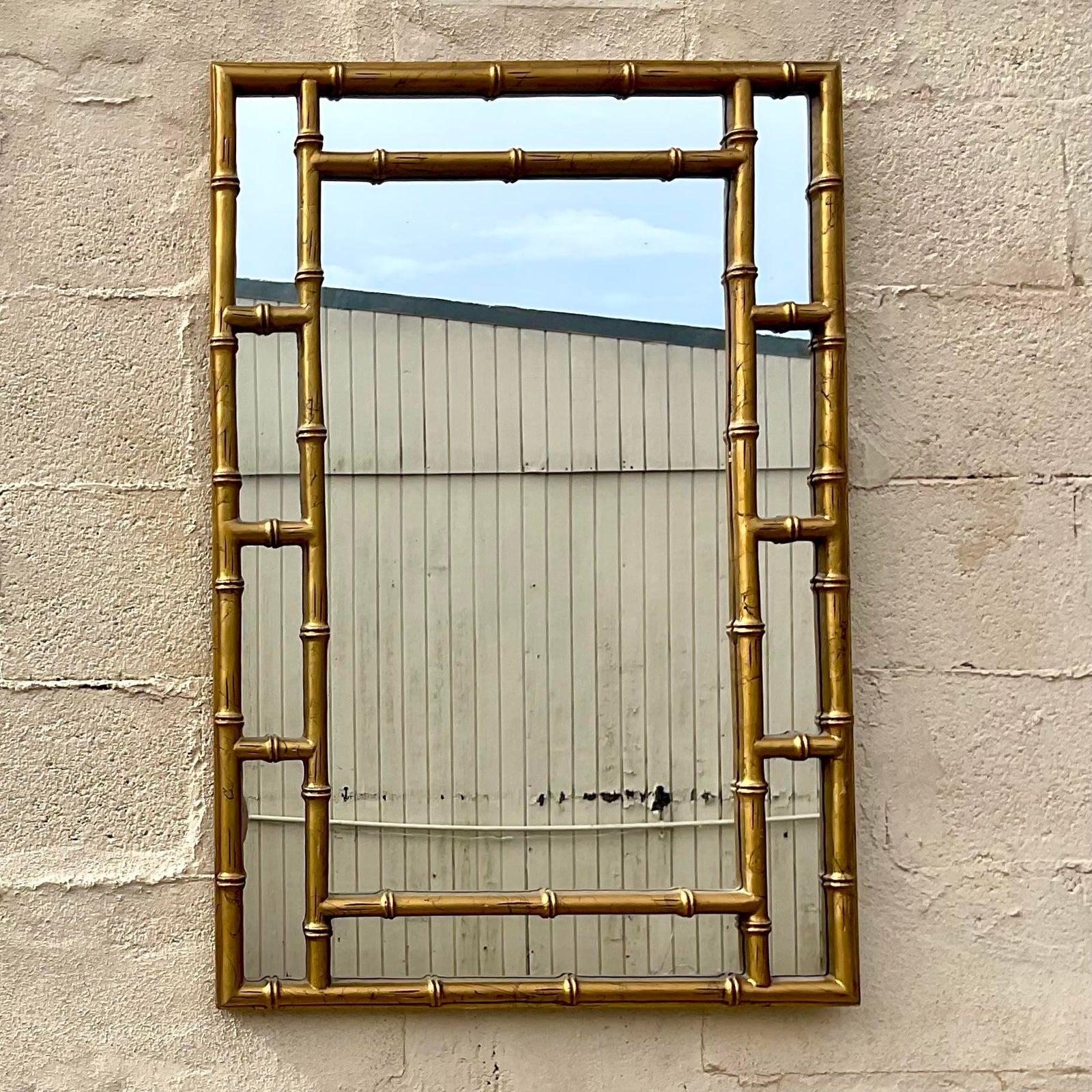 A stunning vintage Boho wall mirror. A chic bamboo frame with a gilt finish. A classic grid design. Acquired from a Palm Beach estate