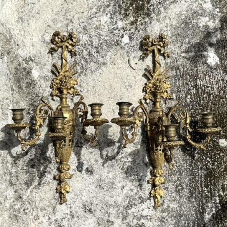 Aporta un toque de opulencia a tu espacio con este exquisito par de candelabros dorados Vintage Regency. Con intrincados detalles dorados, estos apliques están fabricados con un lujoso acabado dorado que captura la grandeza del diseño de la