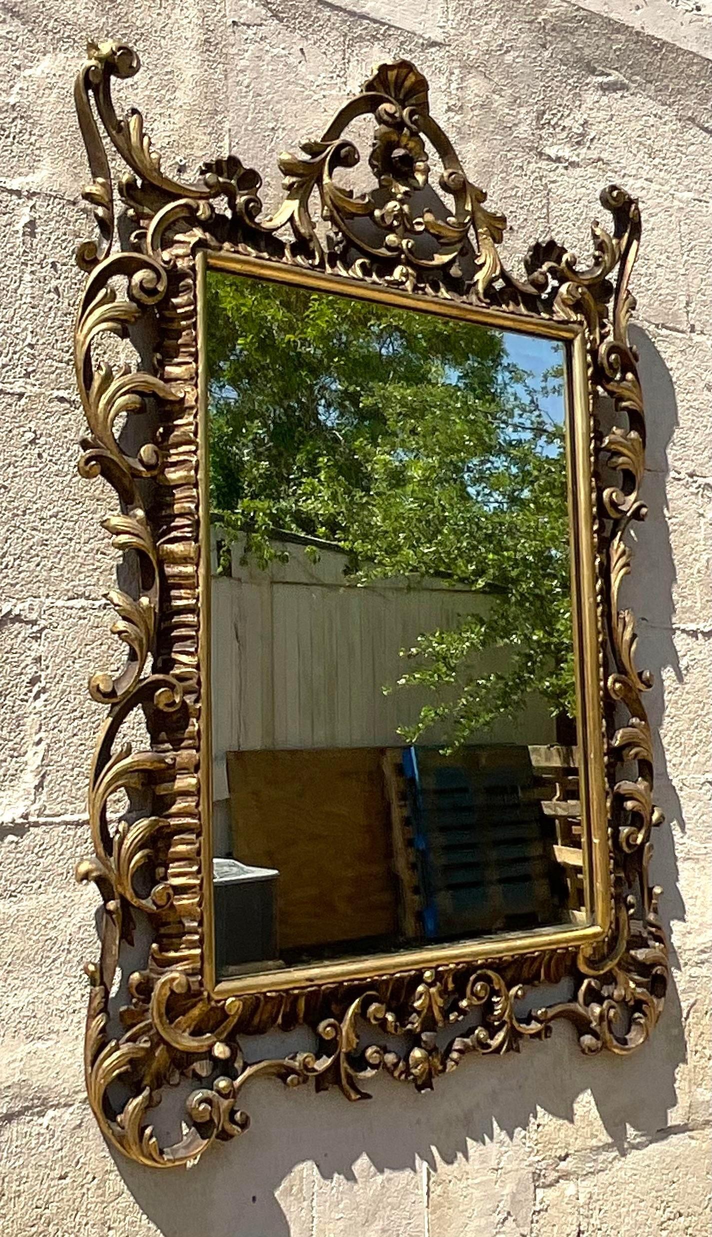 Erleben Sie zeitlosen Luxus mit unserem vergoldeten, geschnitzten Vintage Regency-Spiegel. Dieser von amerikanischer Eleganz durchdrungene Spiegel besticht durch aufwändig geschnitzte Details und eine glänzende Vergoldung. Er verbindet klassisches
