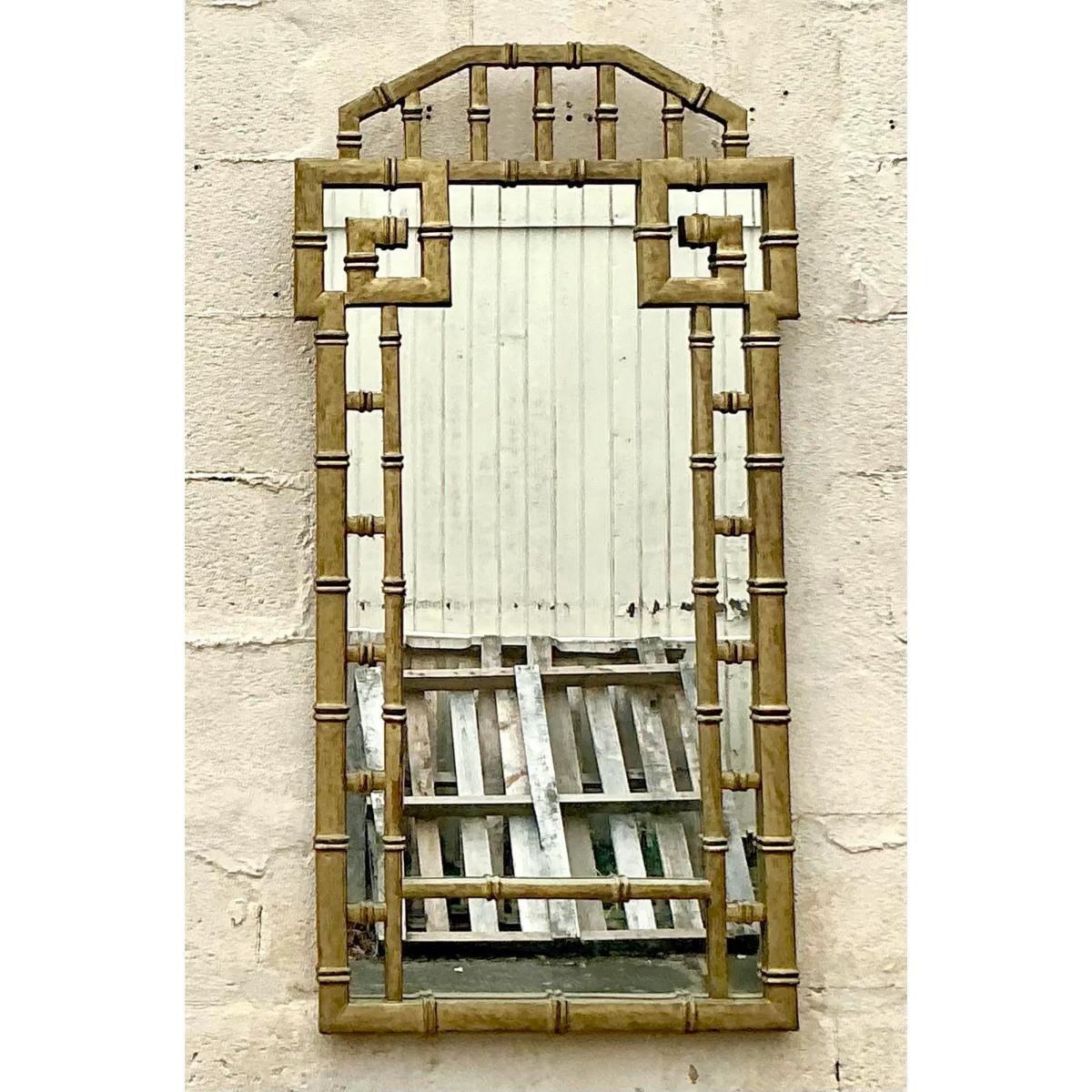 Ce miroir doré vintage Regency présente un remarquable design en forme de clé grecque, d'une élégance intemporelle. Sa finition dorée et son motif classique en font une pièce remarquable, ajoutant une touche de sophistication et de glamour à