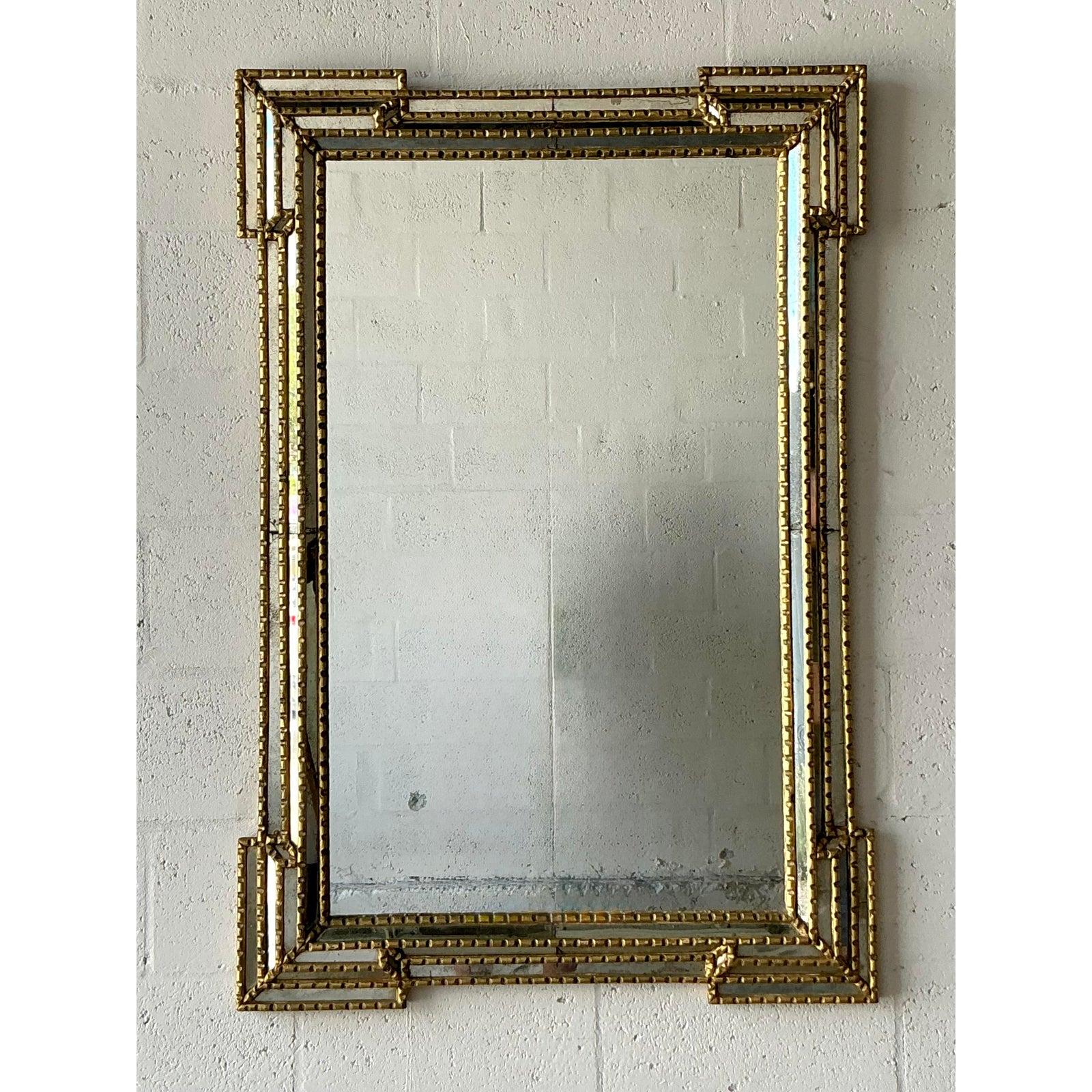 Verleihen Sie Ihrem Raum die zeitlose Eleganz dieses auffälligen vergoldeten Vintage-Spiegels. Die architektonische, gekerbte Silhouette und die detailreiche Perlenleiste, die für eine wunderbare Struktur und visuelles Interesse sorgt, prägen sein