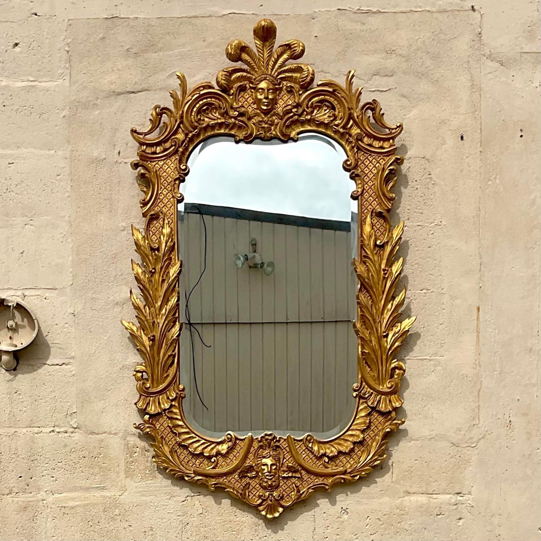 A fantastic vintage Regency wall mirror. A chic gilt plumed monarch carved from wood. Made in Italy. Done in the manner of Carvers Guild. Acquired from a Palm Beach estate.