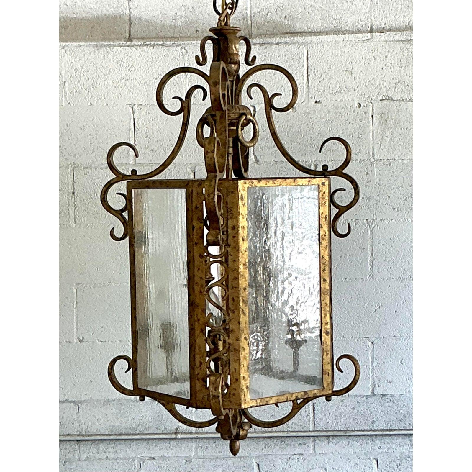 Attira l'attenzione con questa splendida lanterna dorata Vintage Regency, un pezzo straordinario che irradia la grandezza del vecchio mondo. Realizzata con una finitura dorata e anticata, questa lanterna vanta un'imponente silhouette definita da