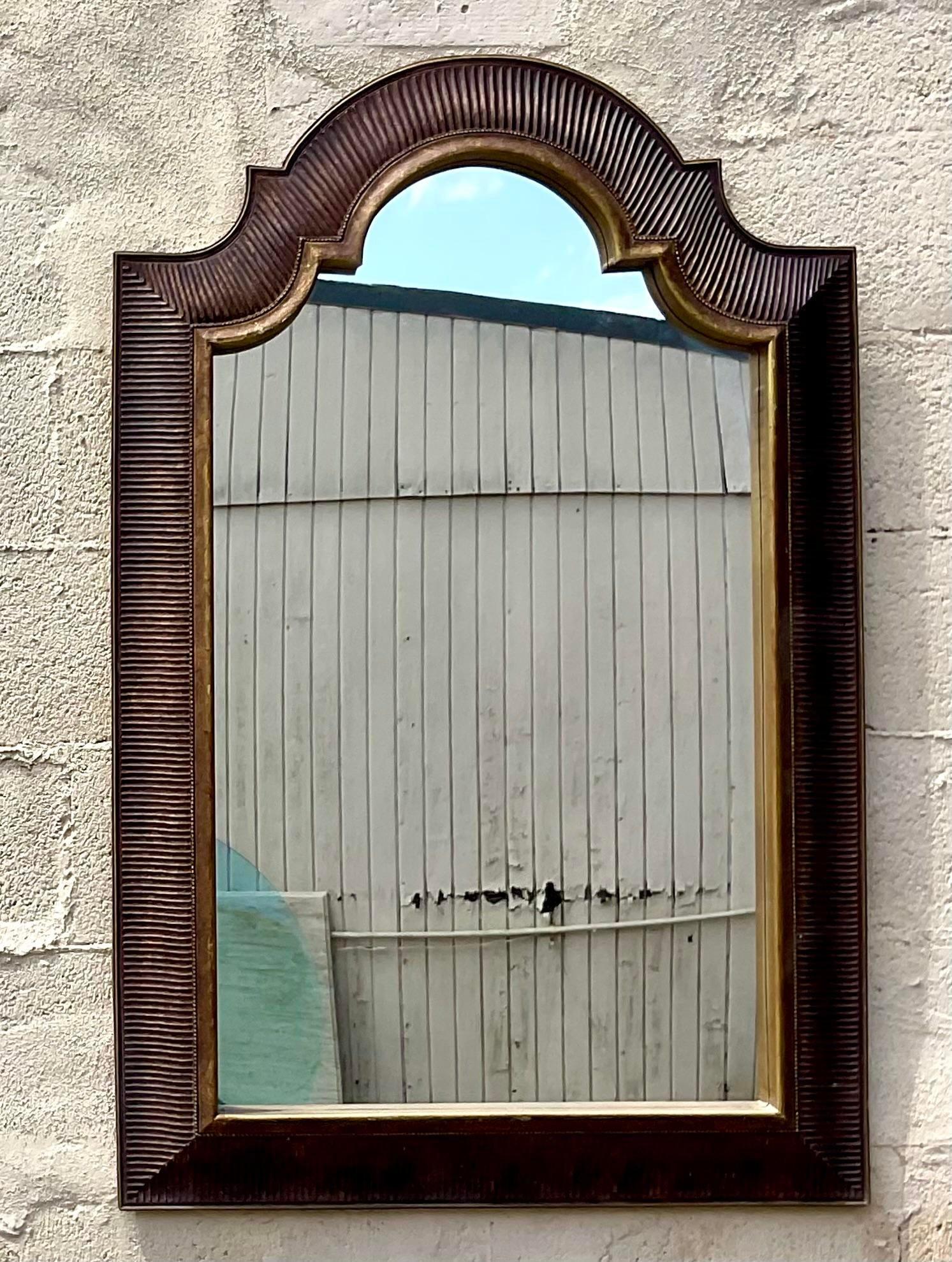 Elevate your decor with this vintage Regency gilt-tipped arched mirror. American-crafted with classic elegance, its arched design and gilt accents add a touch of timeless sophistication, making it a stunning focal point for any room.