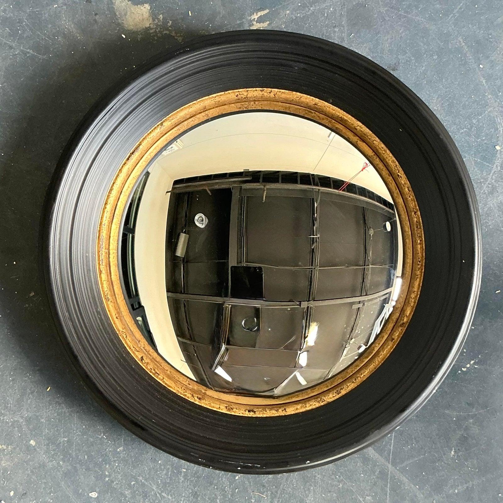 Ajoutez une touche de grandeur historique à votre intérieur avec ce miroir convexe vintage saisissant. Emblème classique du design Feder et Regency, cette pièce présente un cadre en bois profondément tourné et cannelé, fini dans un noir ébonisé