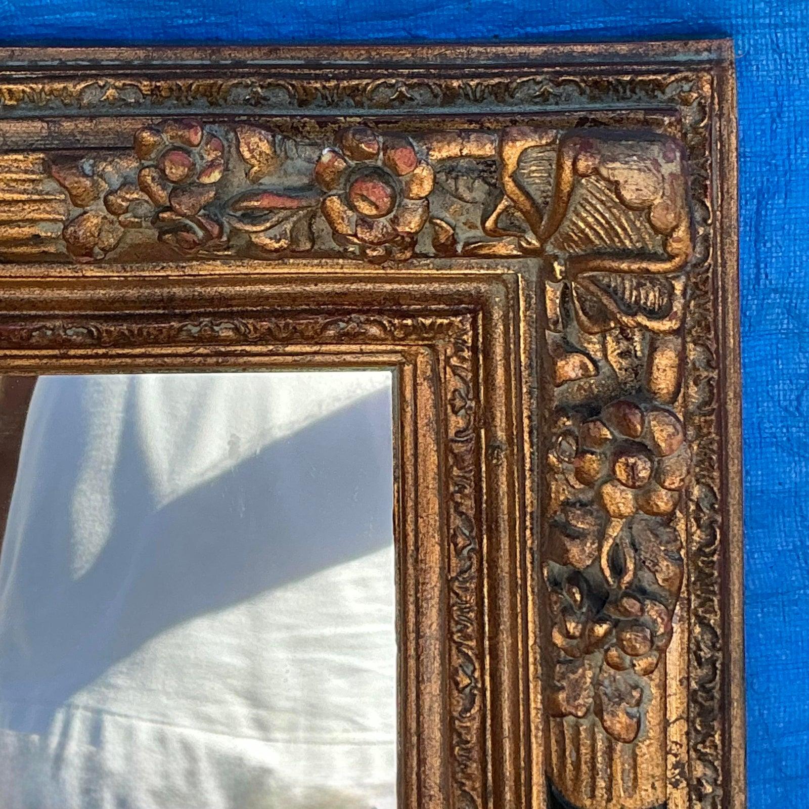 Ce miroir vintage Regency exquis dégage une élégance intemporelle avec son cadre doré orné et ses détails floraux complexes. Le design magnifiquement sculpté, souligné par des accents dorés, ajoute une touche opulente, ce qui en fait une pièce