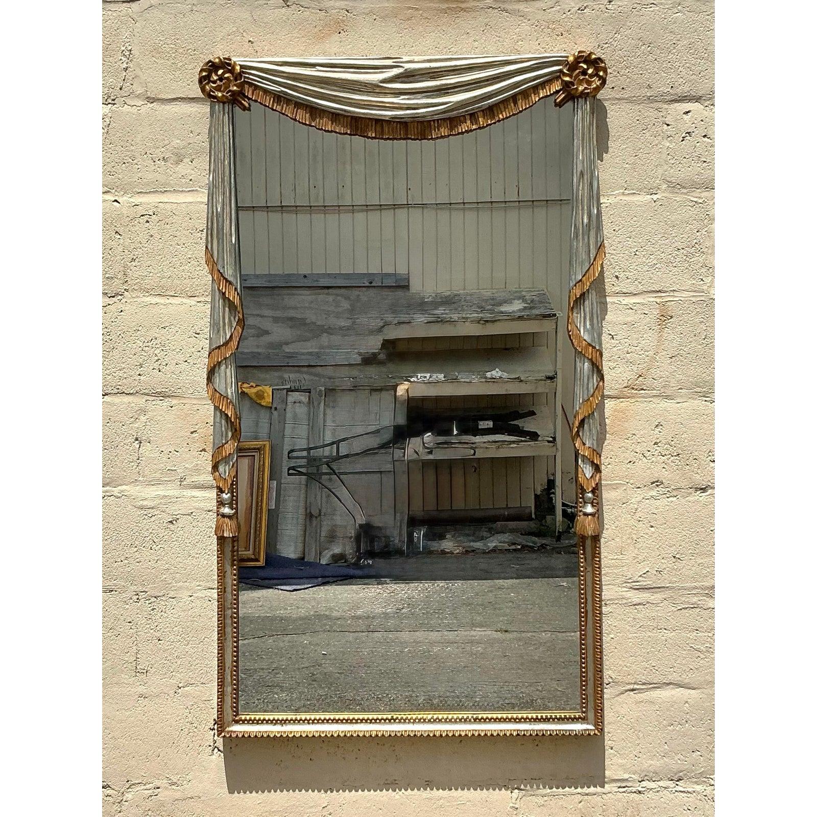 Entrez dans l'élégance intemporelle avec ce miroir Vintage Regency Gilt Tipped Swag, une pièce étonnante qui incarne l'opulence du design de l'époque Regency. Orné d'un drapé gracieux en tissu, rehaussé de glands dorés et de rosettes complexes à