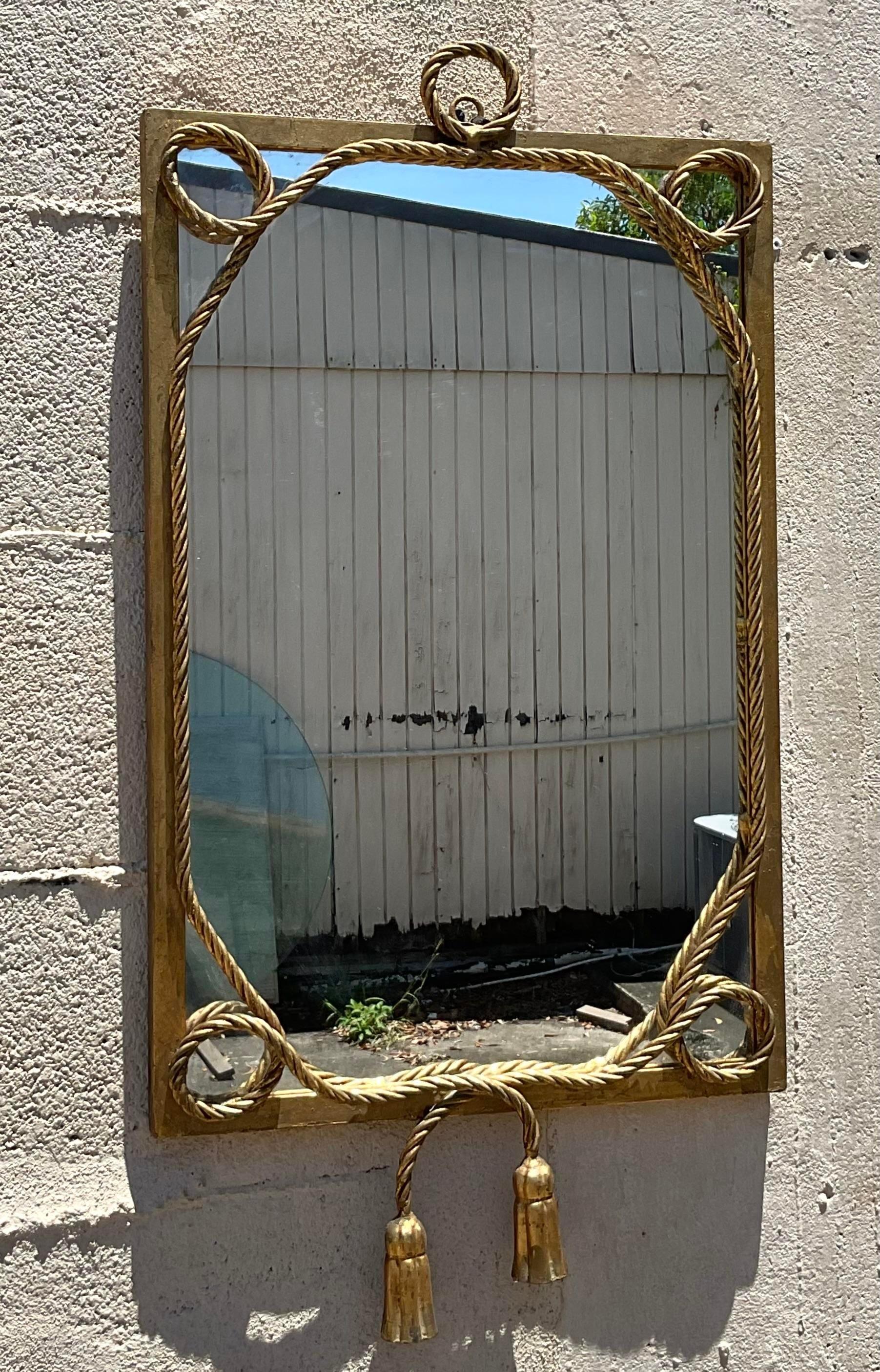 Eleva il tuo spazio con l'eleganza americana senza tempo incarnata da questo specchio vintage Regency dorato con corda ritorta e nappe. Realizzato con dettagli squisiti, il suo design classico aggiunge un tocco di raffinatezza regale a qualsiasi