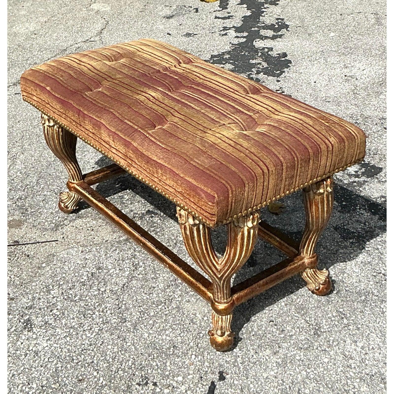 Alliant élégance et confort, ce banc en bois doré Vintage Regency apporte une touche intemporelle à tout espace sophistiqué. Avec ses riches pieds cannelés ornés de sculptures florales et sa finition en feuille d'or vieillie, cette pièce reflète le
