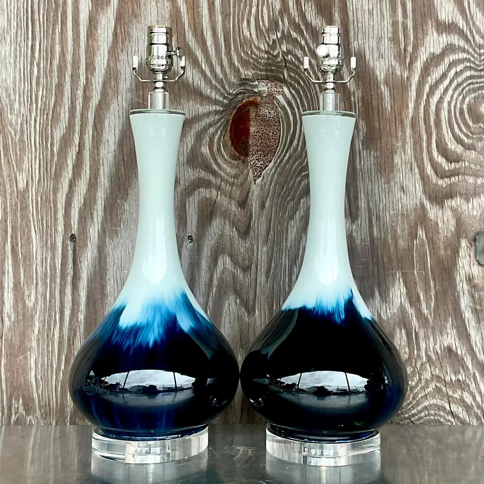 A stunning pair of vintage Coastal glazed ceramic table lamps. Beautiful shades of blue and huge on a classic bulb shape. Fully restored with all new hardware, wiring and lucite plinths. Acquired from a Palm Beach estate.