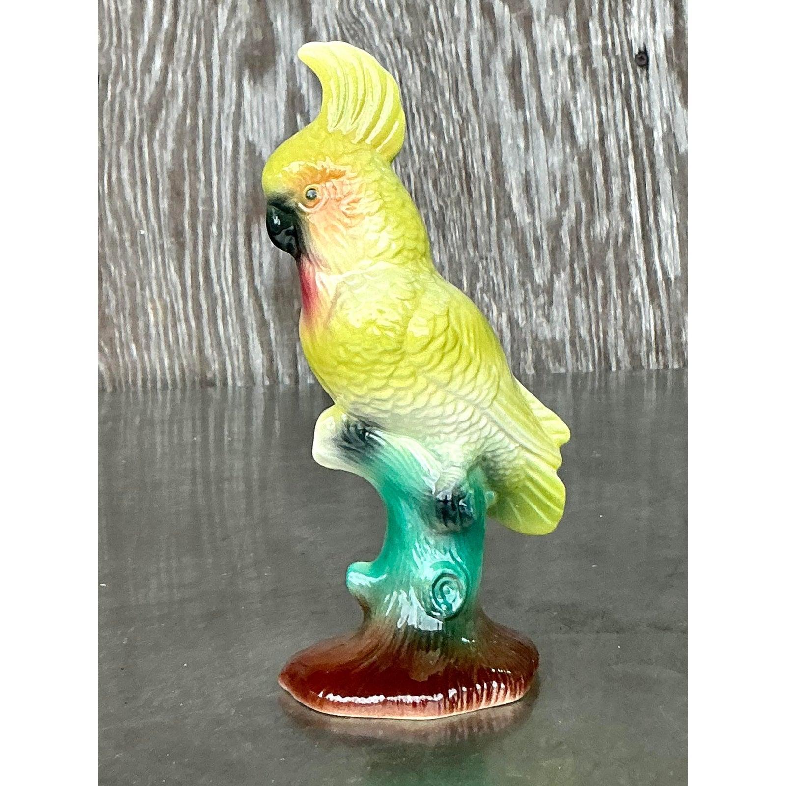 Ajoutez une touche de charme tropical à votre décor avec ce superbe cacatoès en céramique émaillée de style Regency. Fabriquée avec des détails complexes, cette figurine vibrante présente un corps jaune-vert saisissant avec des touches subtiles de