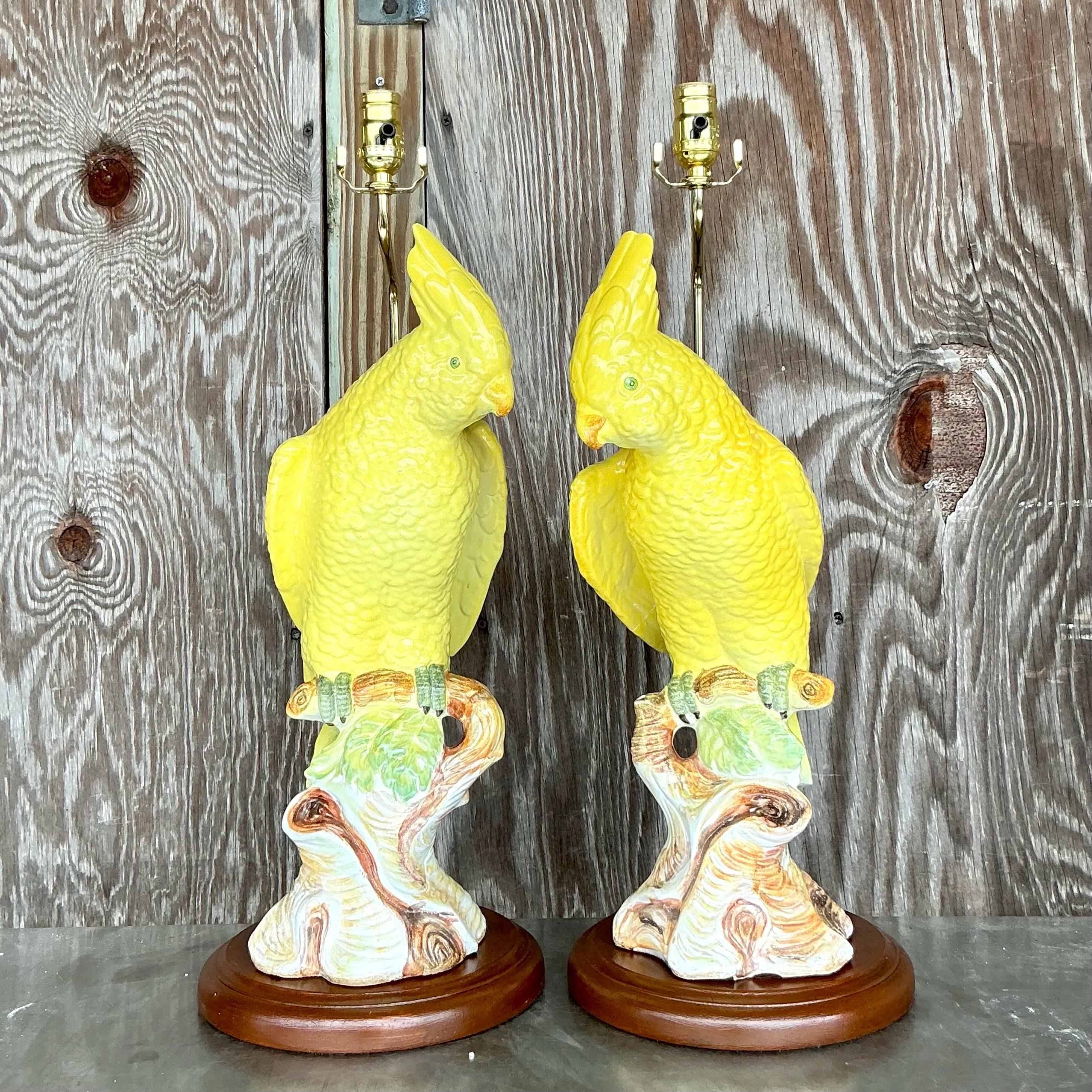 This striking pair of vintage cockatoo lamps exudes regency flair and tropical elegance. Crafted from glazed ceramic, each lamp features a beautifully detailed yellow cockatoo perched on a textured tree trunk, accented with naturalistic tones of