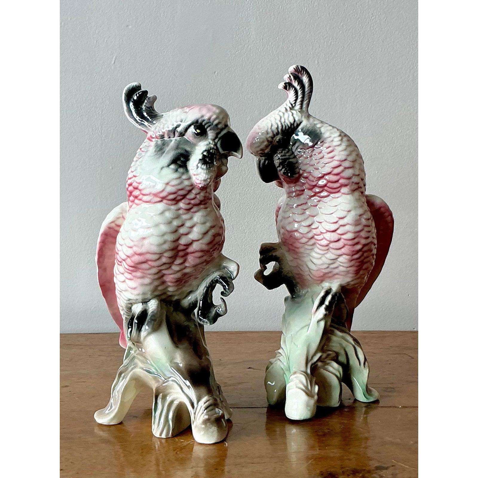 Infondi nella tua casa il fascino esotico e l'eleganza giocosa di questa splendida coppia di statuette di cacatua in ceramica vintage. Realizzato con maestria, ogni uccello presenta una splendida smaltatura dipinta a mano di rosa e grigio tenui, che