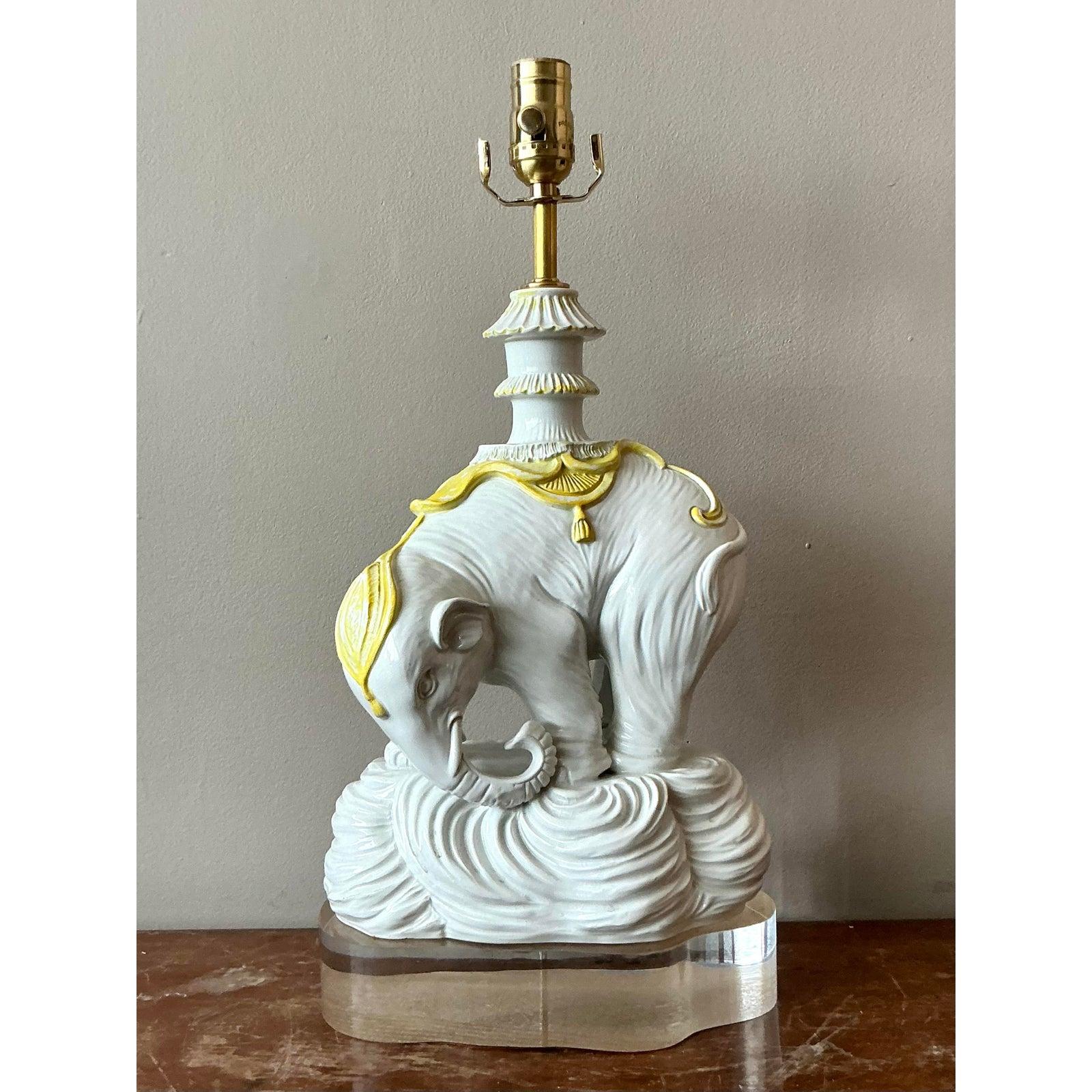 Elevate your interior with this captivating Hollywood Regency glazed ceramic elephant lamp, a true conversation starter from the mid-20th century. This exquisite piece masterfully blends whimsical charm with elegant design, featuring a beautifully