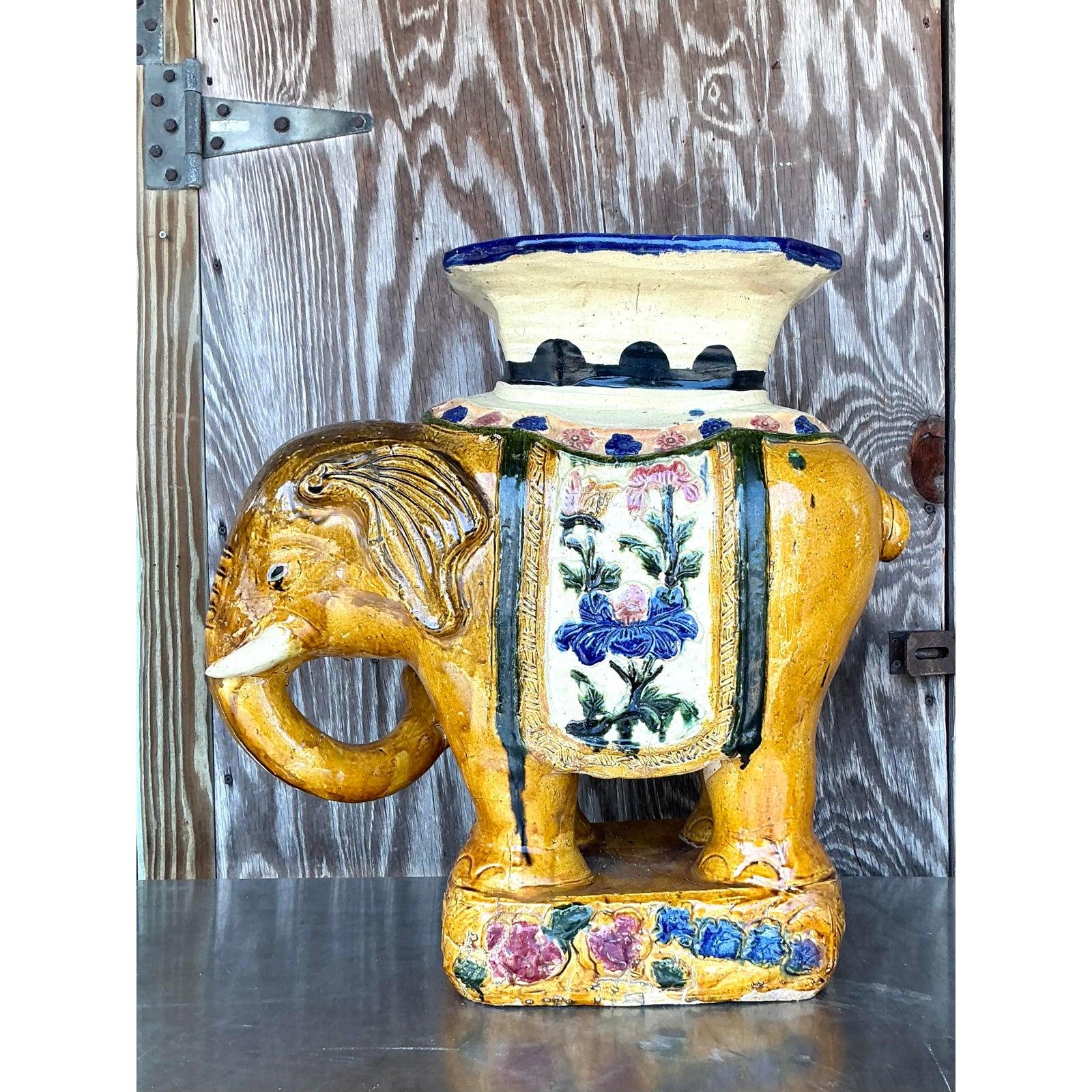 Añade un toque de elegancia exótica a tus interiores con este impresionante elefante de cerámica esmaltada vintage, una pieza que aúna el encanto caprichoso y la sofisticación de la Regencia. Hecha a mano con intrincados detalles, esta cerámica