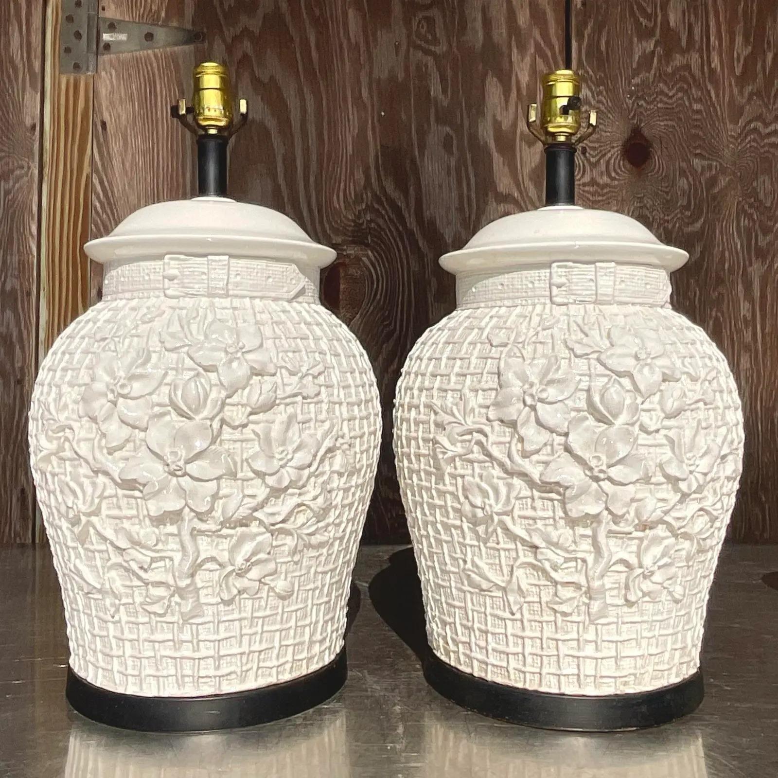 Une fabuleuse paire de lampes de table Regency vintage. Magnifiques lampes en céramique émaillée au design floral Icing chic. Repose sur un socle noir. Acquis d'une propriété de Palm Beach.