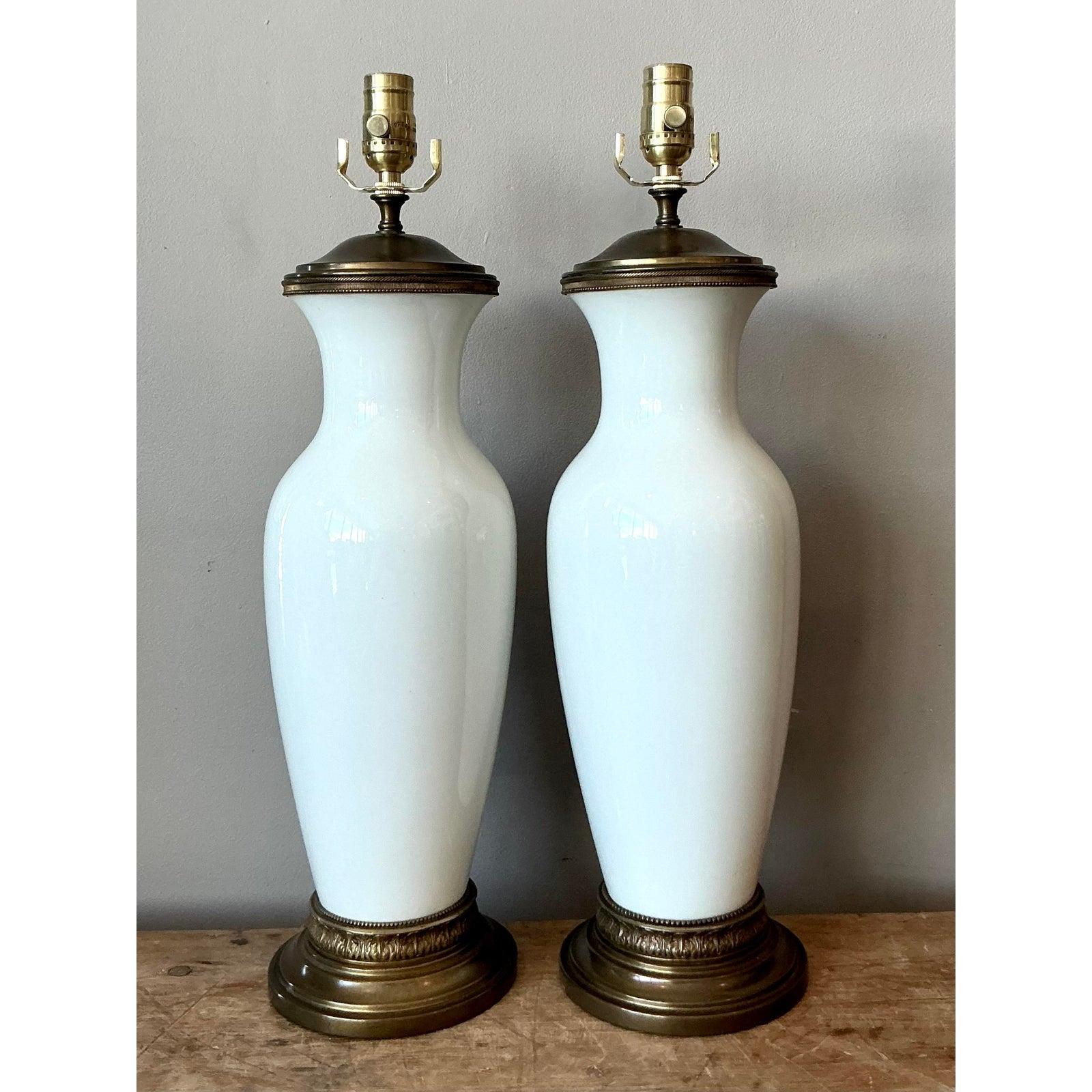 Cette exquise paire de lampes de table présente des formes de vases classiques fabriquées en céramique blanche immaculée et hautement polie, évoquant l'élégance intemporelle de la porcelaine Blanc de Chine. Les silhouettes gracieuses en forme de