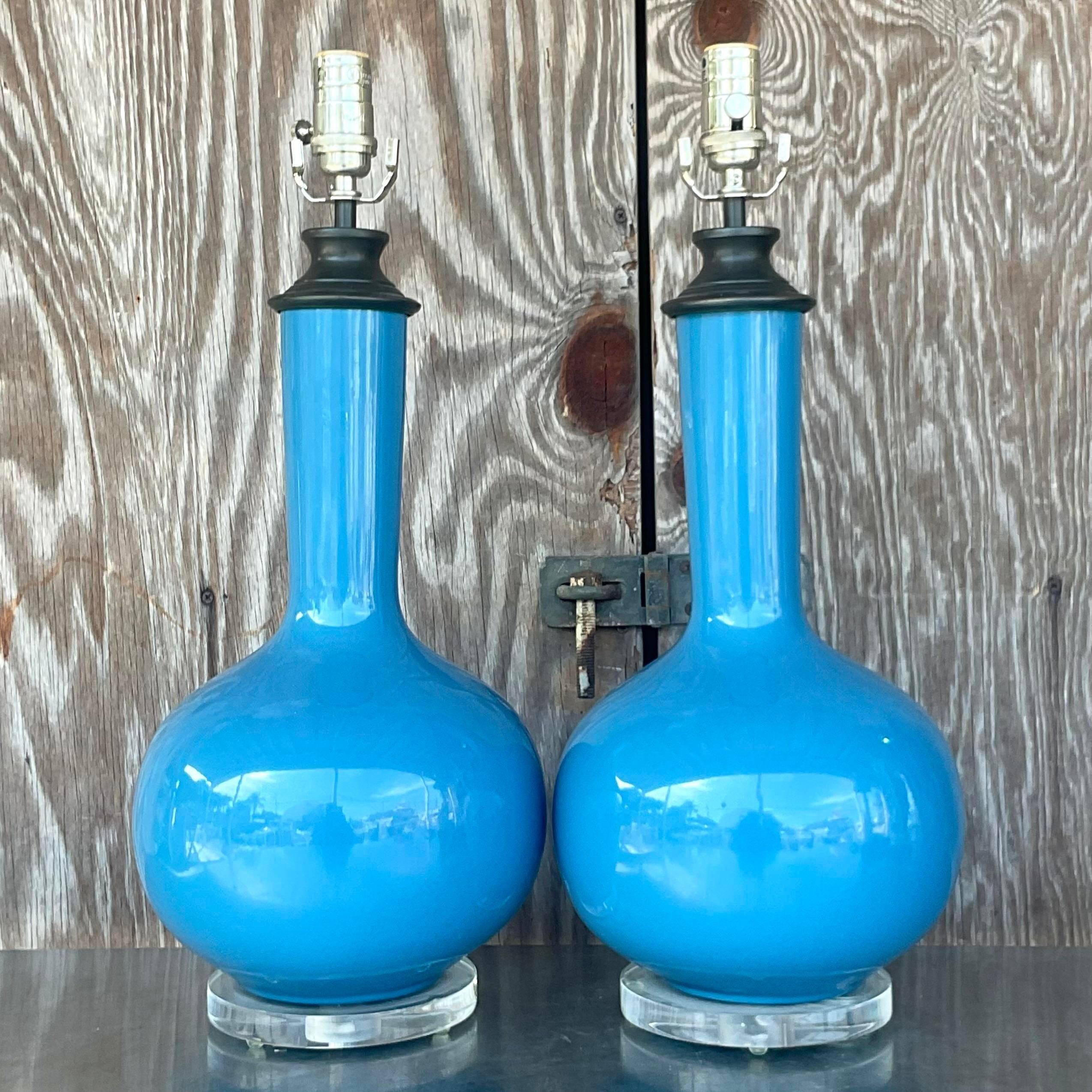 A fabulous pair of vintage Regency table lamps. Brilliant blue onion bulbs on lucite plinths. Acquired from a Palm Beach estate.
