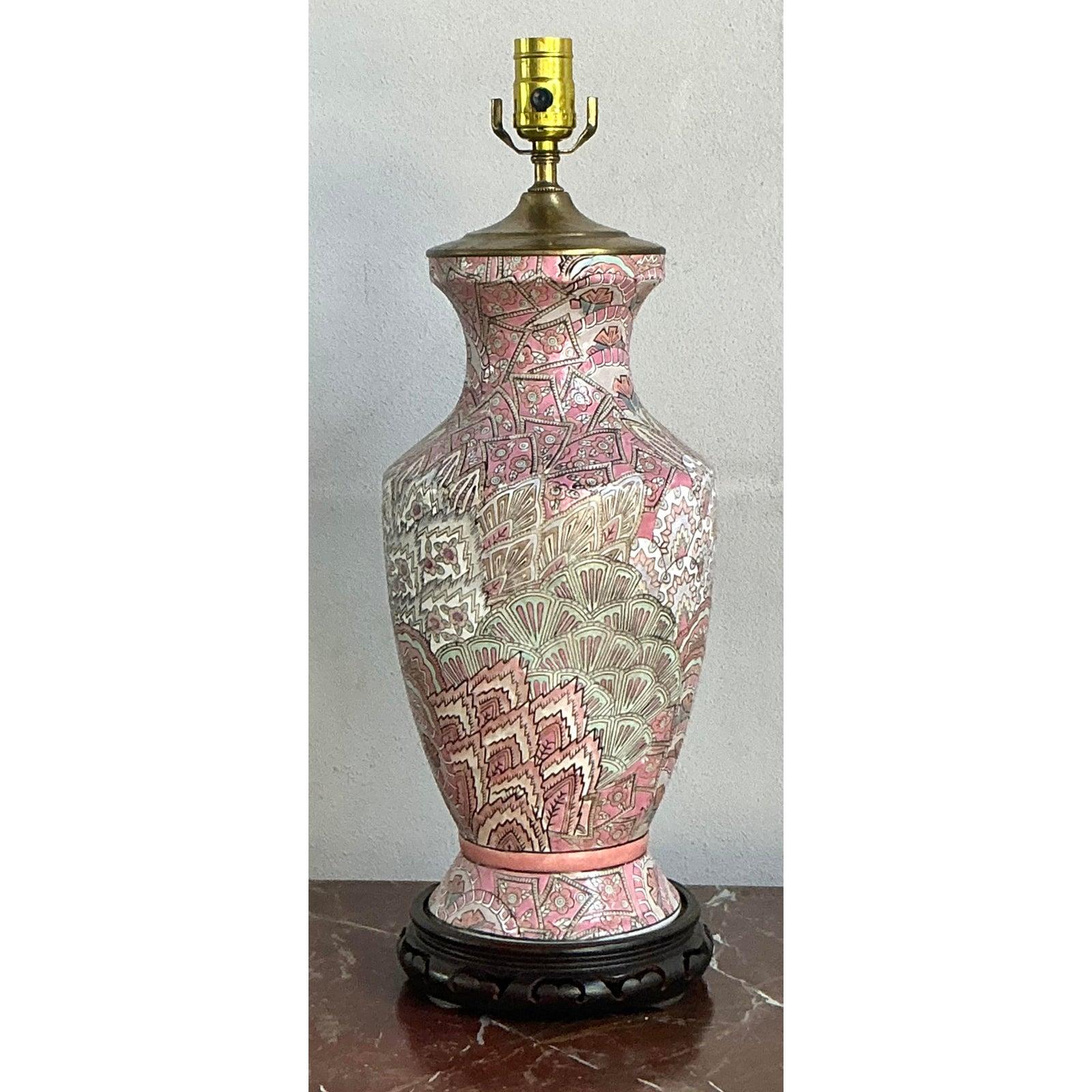 Découvrez l'élégance exotique de cette lampe à poser vintage d'inspiration asiatique. Le vase balustre classique est magistralement embelli par des sculptures complexes en bas-relief représentant des dragons mythiques tourbillonnant au milieu de