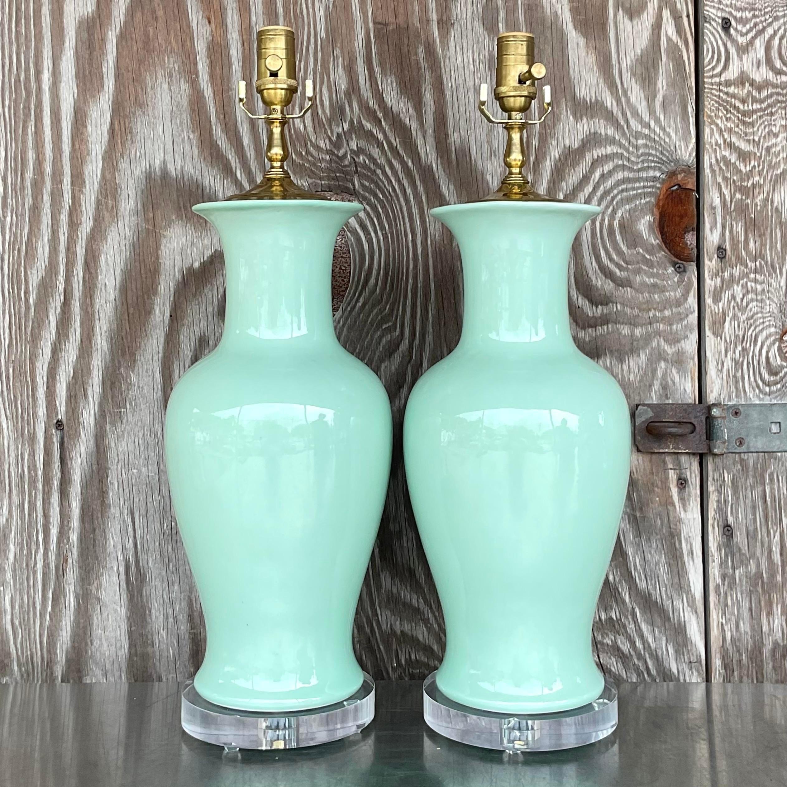 A gorgeous pair of vintage Regency table lamps. A chic pale mint green in a glazed ceramic finish. Fully restored with all new wiring, hardware and lucite plinths. Acquired from a Palm Beach estate.