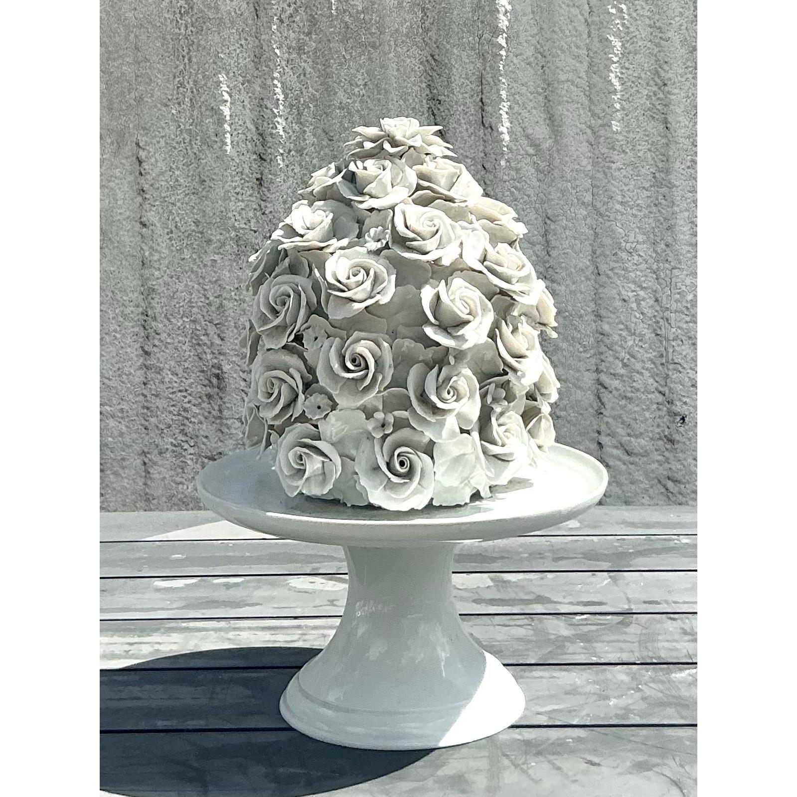 Ce gâteau à la rose en porcelaine émaillée de style Regency est une œuvre d'art d'une qualité exceptionnelle. Intricatement sculptées, de délicates roses en porcelaine tombent en cascade sur l'ensemble de la forme, créant une esthétique romantique