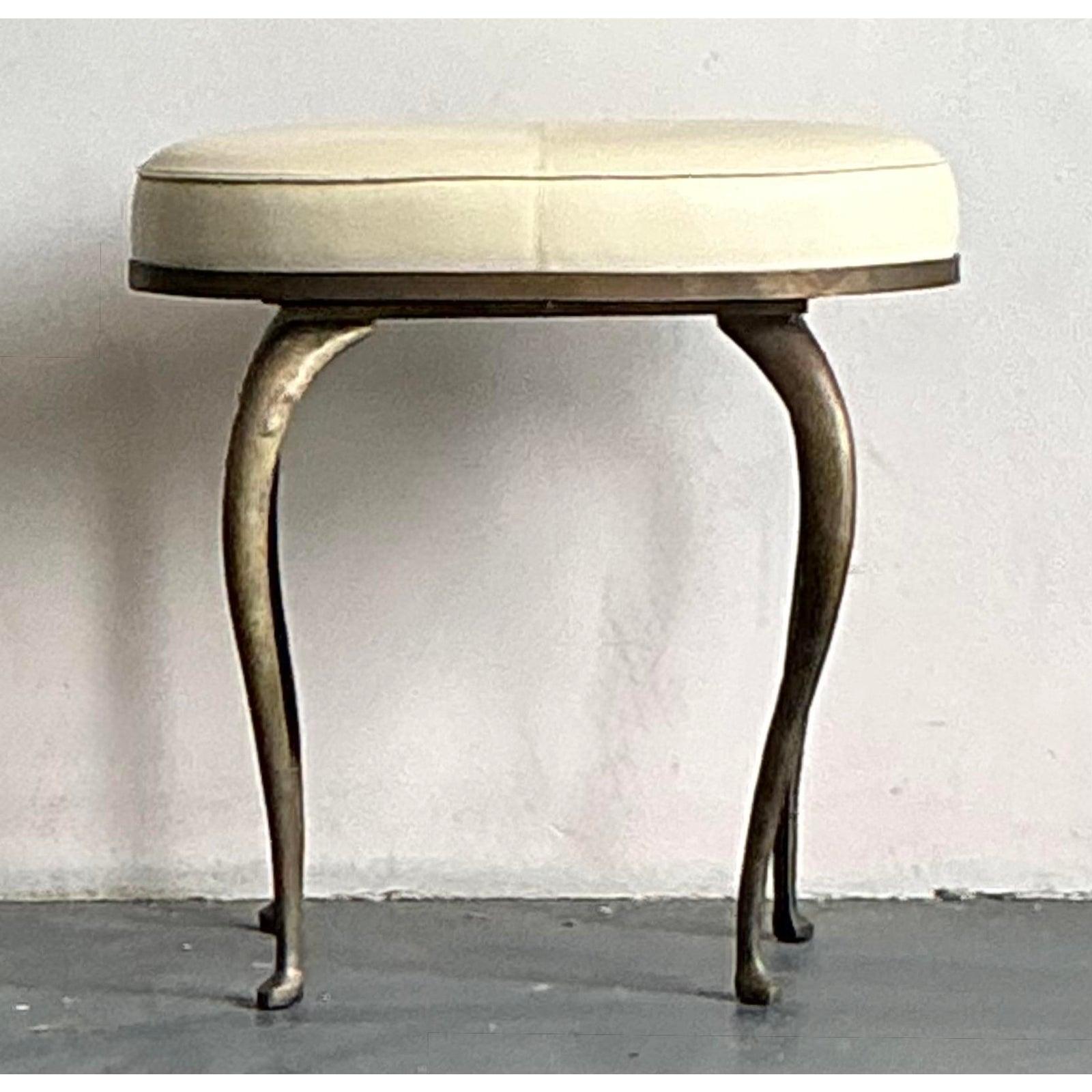 Add a touch of refined glamour to your interior with this elegant vintage Hollywood Regency tufted oval low stool. This charming piece features a comfortably padded, off-white upholstered top, meticulously tufted in the center to create a classic,