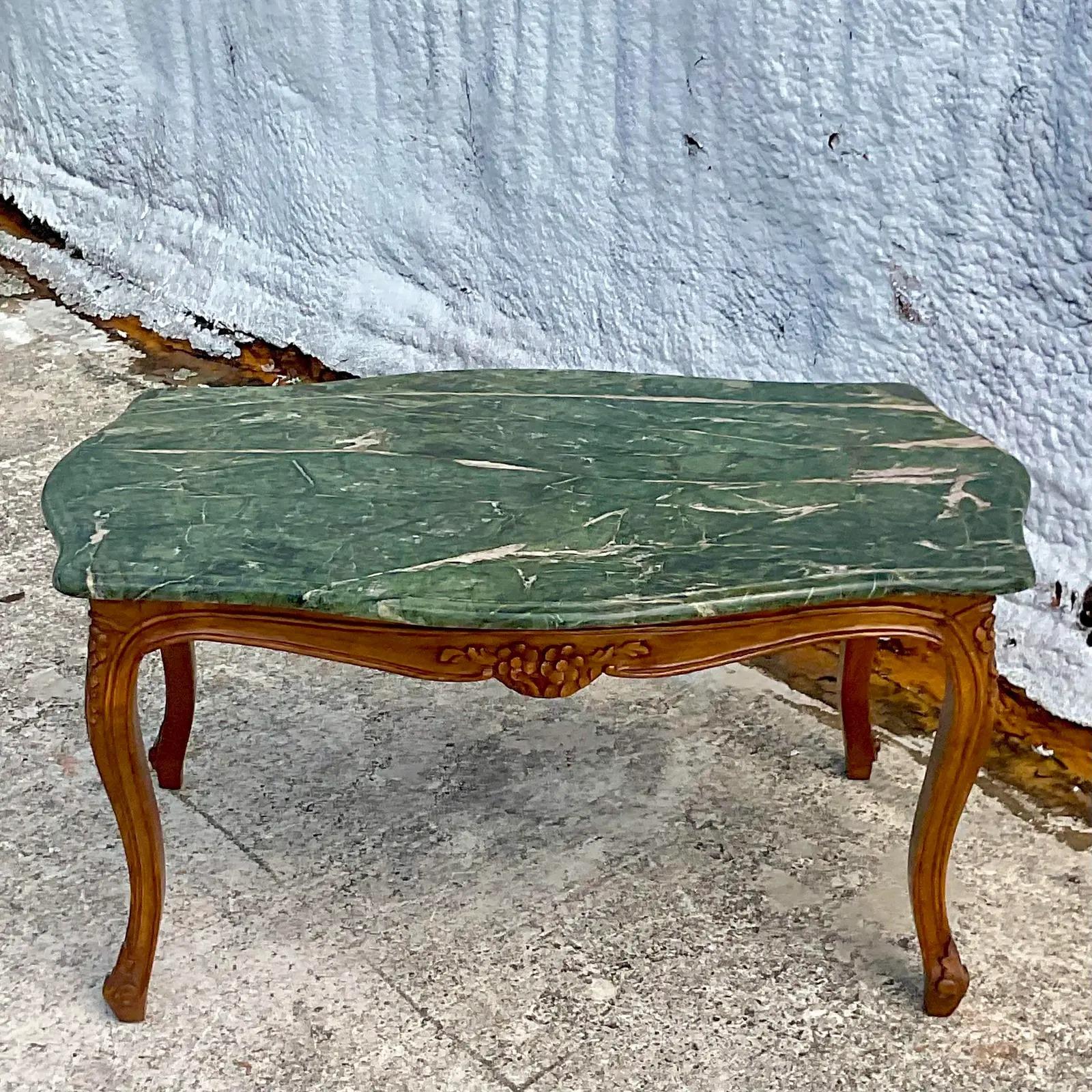 A chic vintage Regency coffee table. Gorgeous green marble top and a hand carved frame. Acquired from a Palm Beach estate.