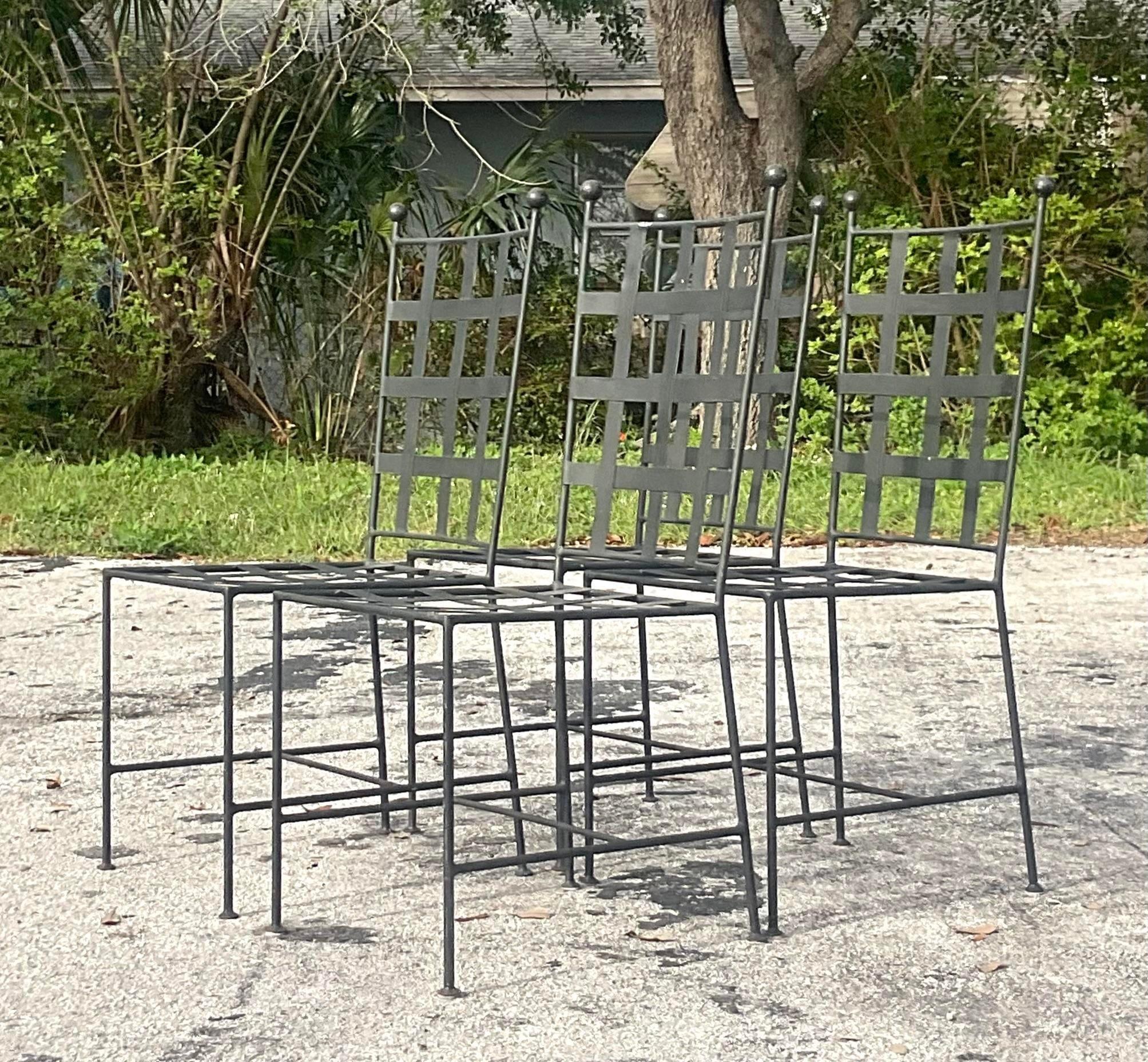 A fabulous set of four vintage Coastal outdoor dining chairs. A chic wrought iron frame with a beautiful banded grid design. Acquired from a Palm Beach estate. 