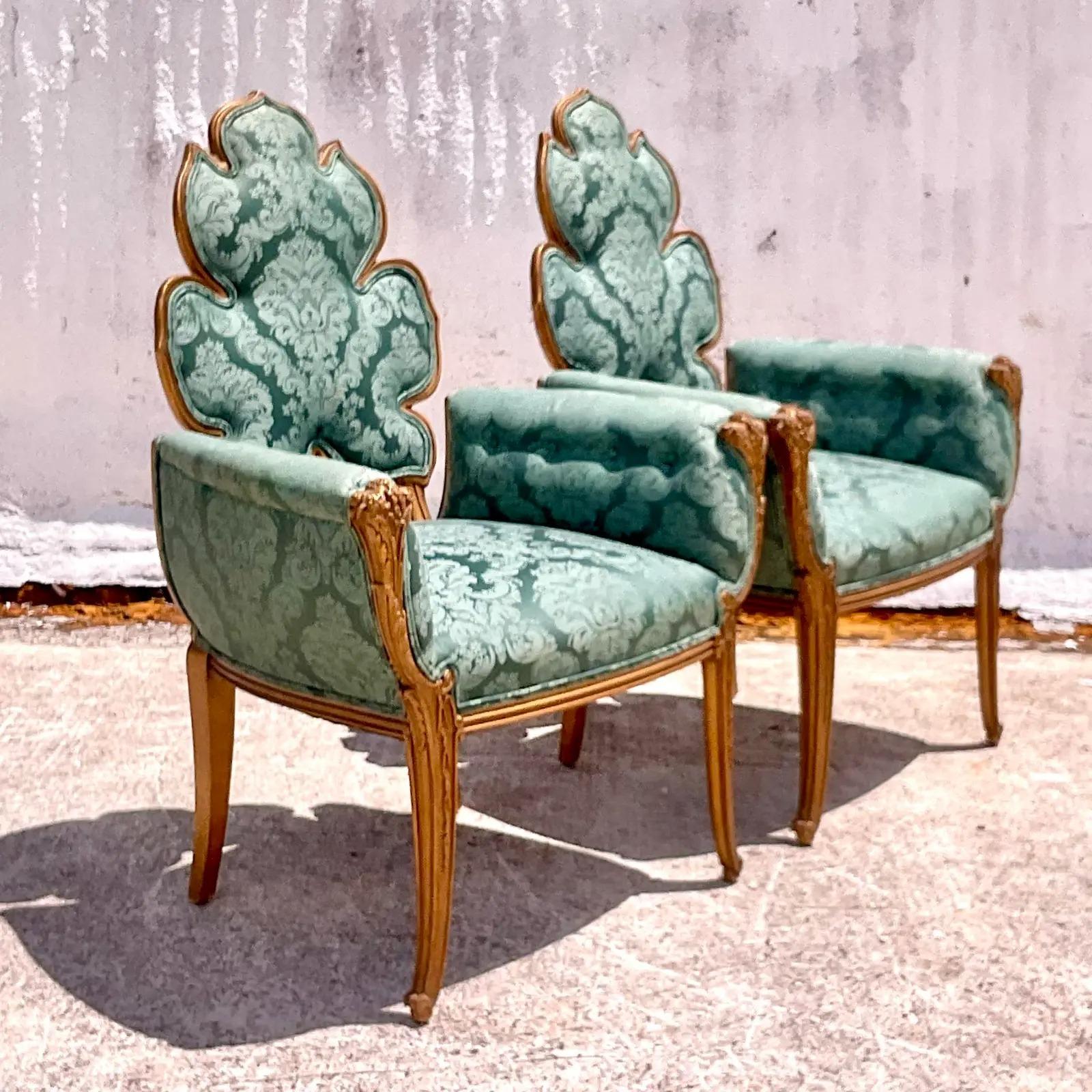 A spectacular pair of vintage Hand carved arm chairs. Made by the iconic Grosfeld House. Beautiful and rare leaf back shape. Covered in an Emerald green jacquard. Acquired from a Palm Beach estate.

The chairs are in great vintage condition. Minor