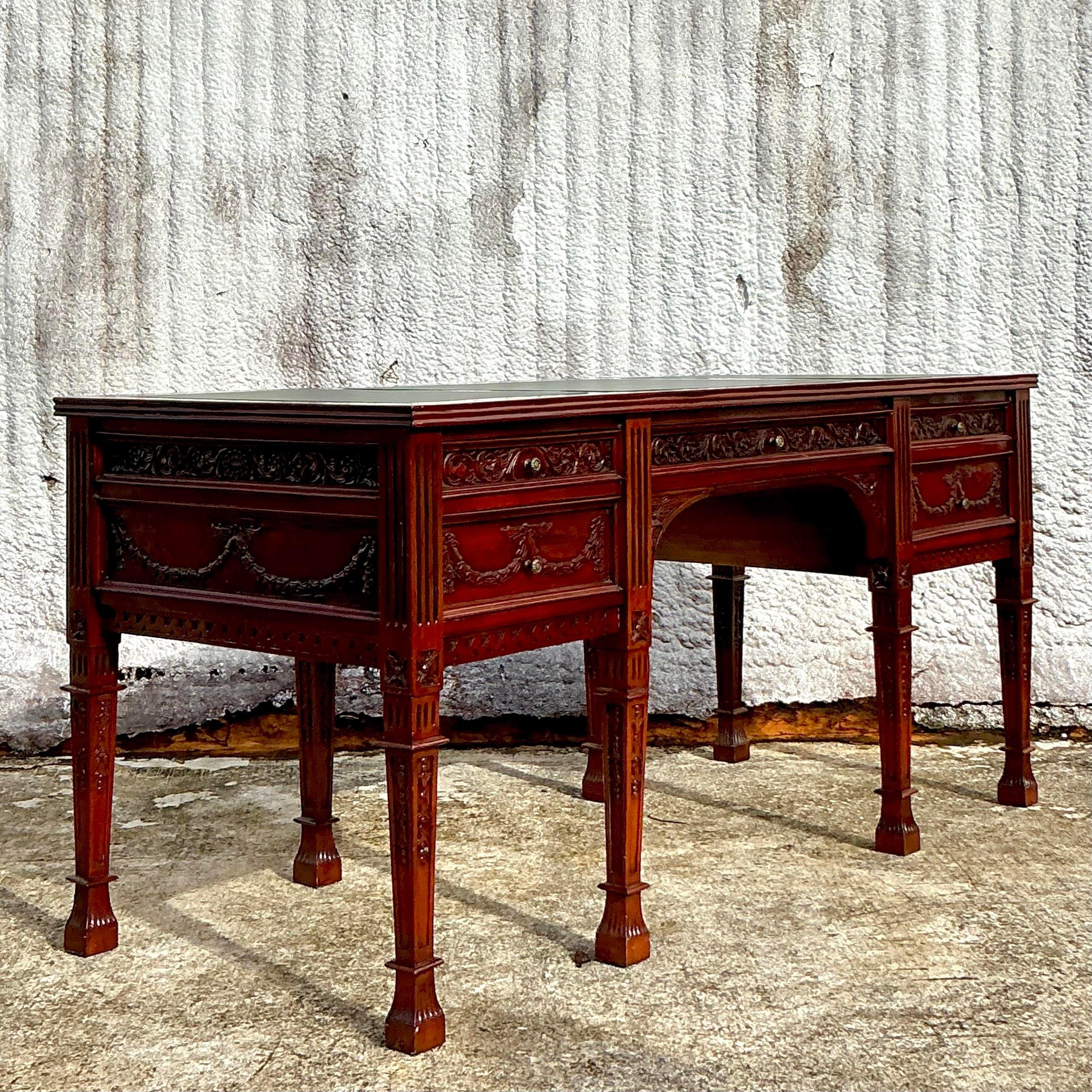 Elevate your workspace with this exquisite Vintage Regency Hand-Carved Executive Desk. Expertly crafted, this desk features intricate hand-carved details, embodying the opulence and refinement of Regency design. The rich wood finish and elegant