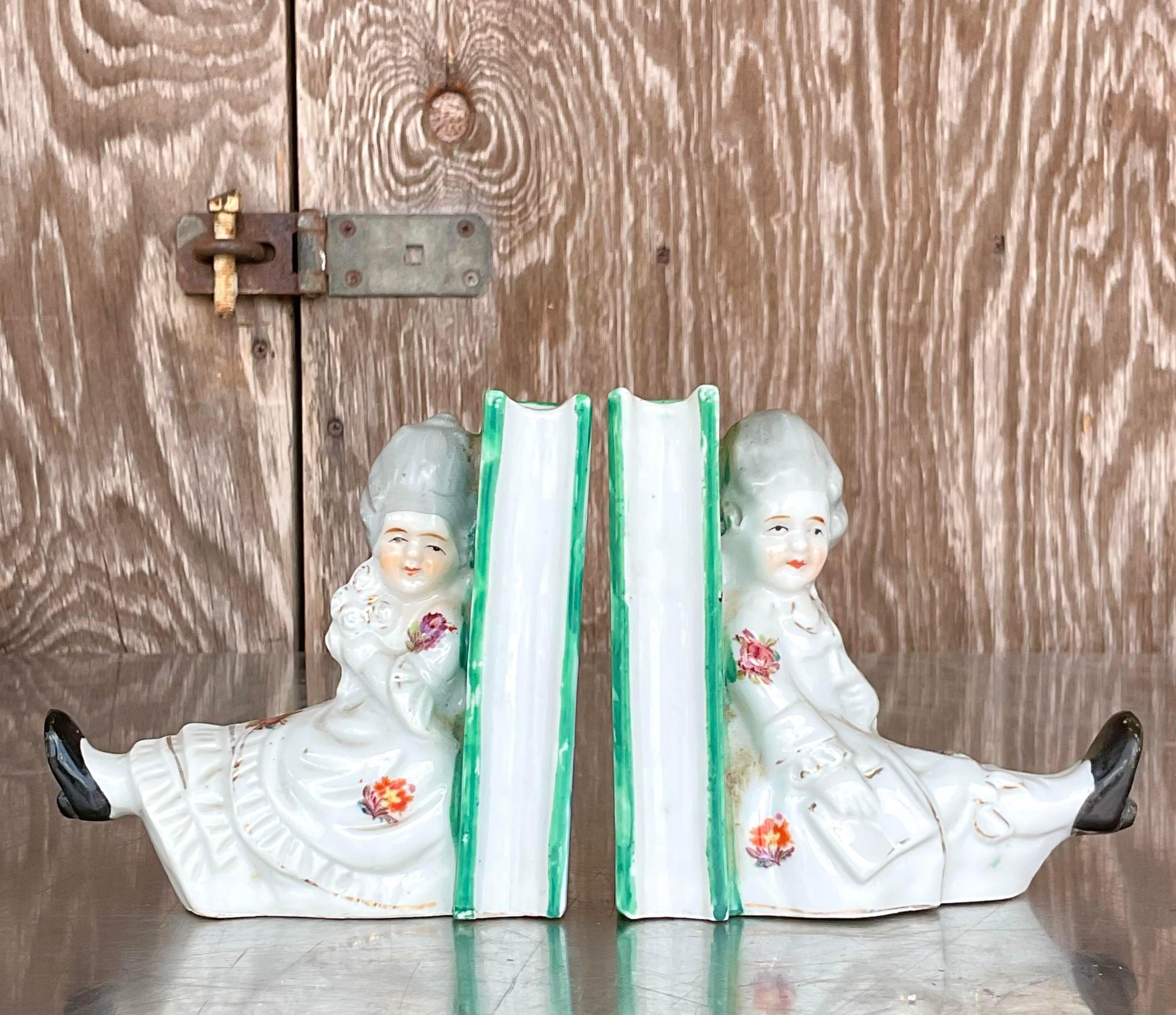 A fabulous pair of vintage Regency bookends. A charming little couple in period dress. Hand painted detail on a ceramic cast. Acquired from a Palm Beach estate. 