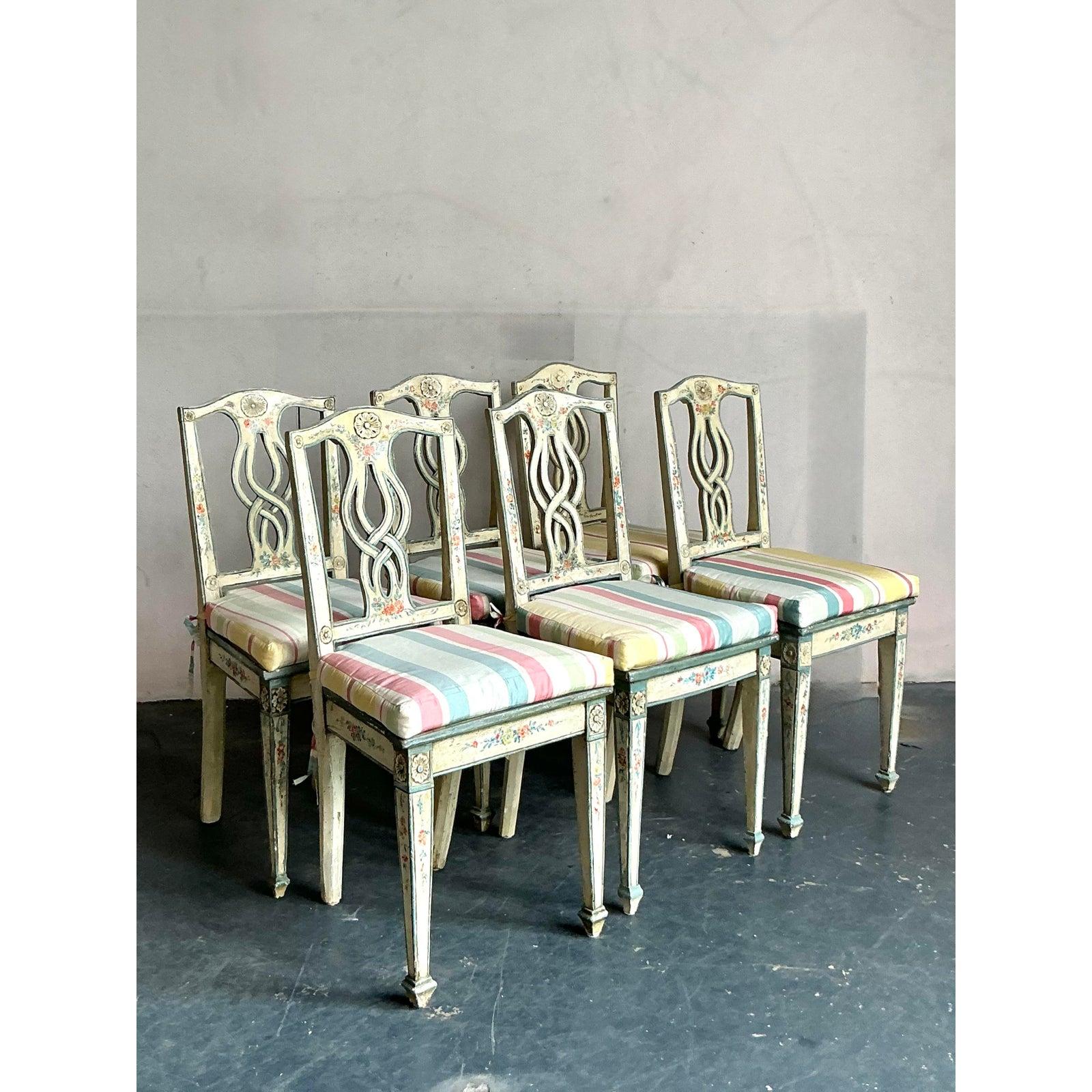 Infondi nel tuo spazio da pranzo un'atmosfera romantica e d'altri tempi con questo squisito set di sei sedie da pranzo vintage. Realizzata magistralmente in stile neoclassico italiano, ogni sedia presenta un'elegante struttura dipinta a mano con una