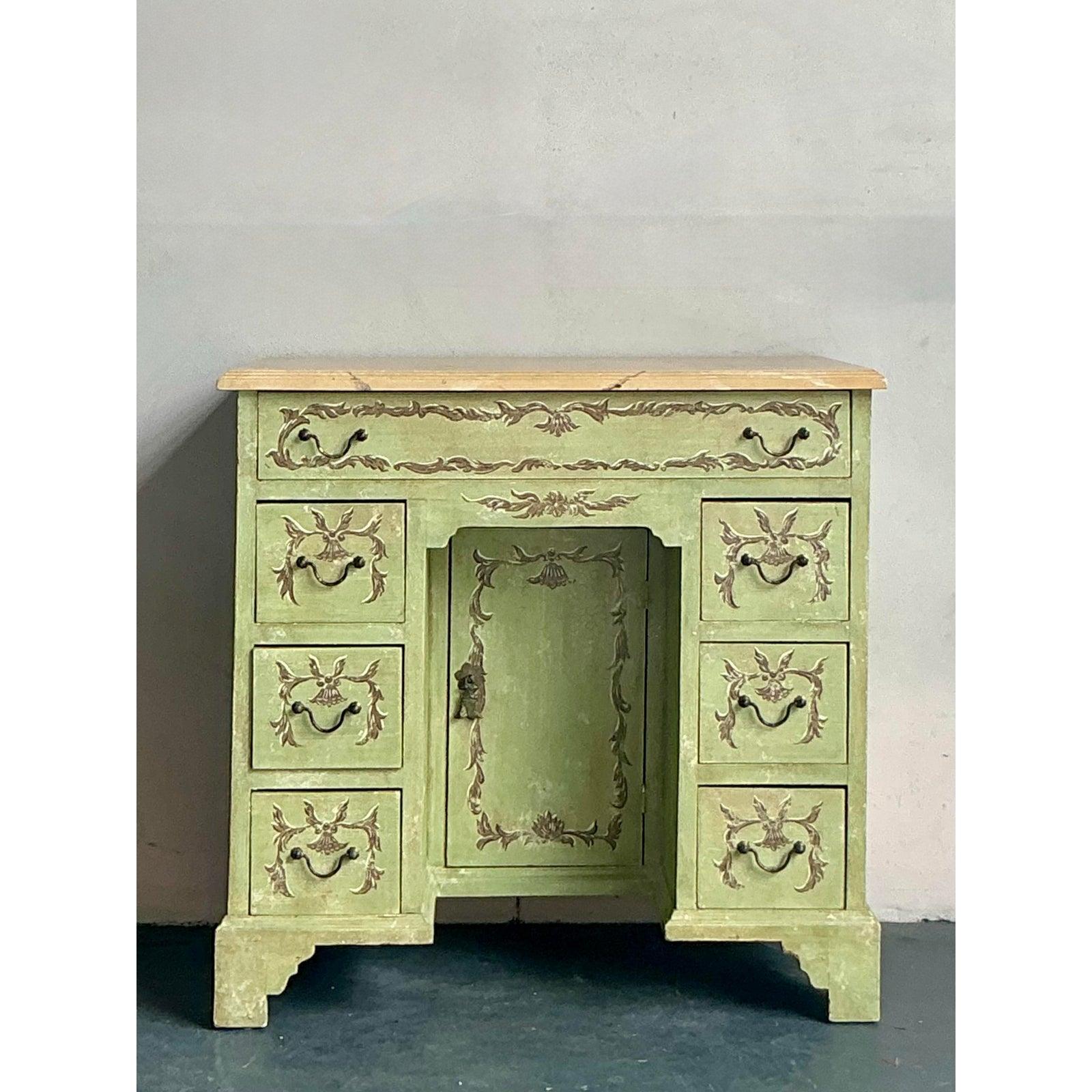 Eleganza per il tuo spazio con questo raffinato tavolino da toilette Vintage Regency dipinto a mano, un pezzo affascinante che parla di eleganza senza tempo e di maestria artistica. Adornata da un'accattivante finitura verde salvia, questa scrivania