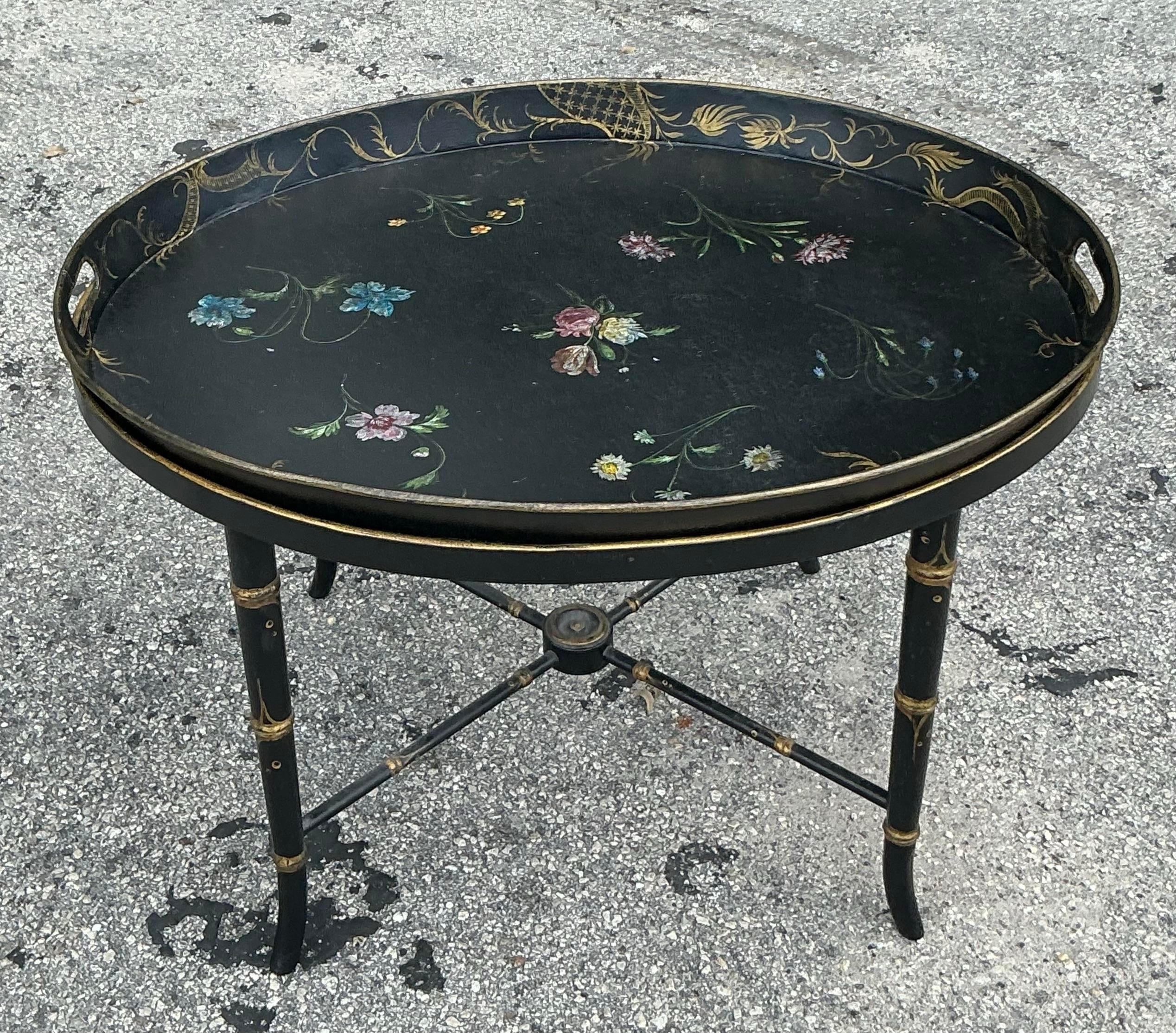 Introducing our Vintage Regency Hand Painted Tole Tray Table, inspired by the elegant designs of John Roselli. This American-style table features a beautifully hand-painted tray with intricate floral patterns, set atop a sturdy folding base. Perfect