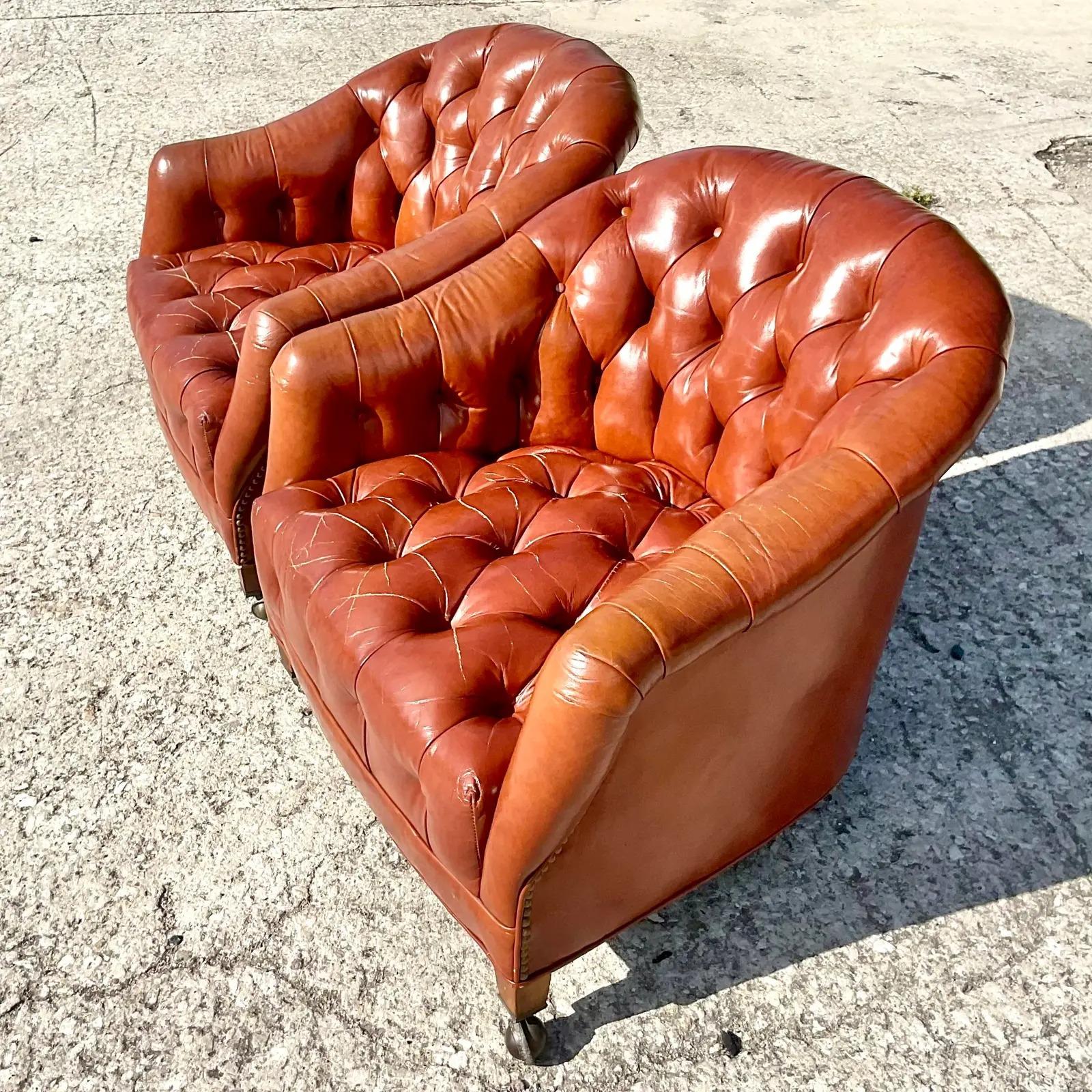Fantastic pair of vintage Boho leather chairs. Beautiful tufted design on a tub shape. Casters on legs for easy movement. Marked on the bottom as property of The Bank of Palm Beach so they have some serious provenance. Acquired from a Palm Beach