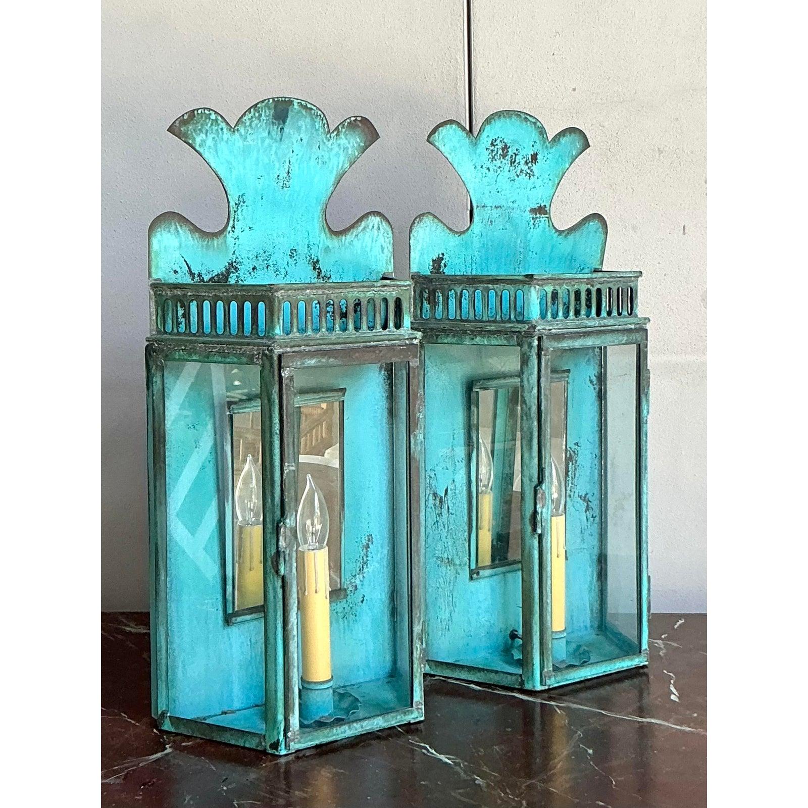Illuminate your space with the dramatic flair of this exceptional pair of vintage lantern sconces from the Hillbrook Collection. Each sconce features a striking, flame-like crest and intricate gallery detailing, all rendered in metal with a stunning