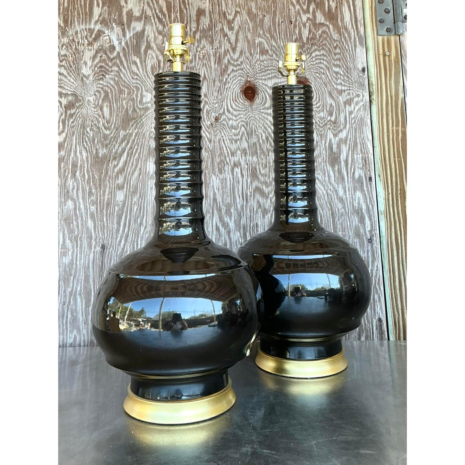 Make a bold statement with this striking pair of vintage Regency Hwang Bishop glazed ceramic lamps. Featuring a sculptural form with a ribbed column neck and rounded gourd base, these lamps exude timeless elegance with a modern twist. The glossy