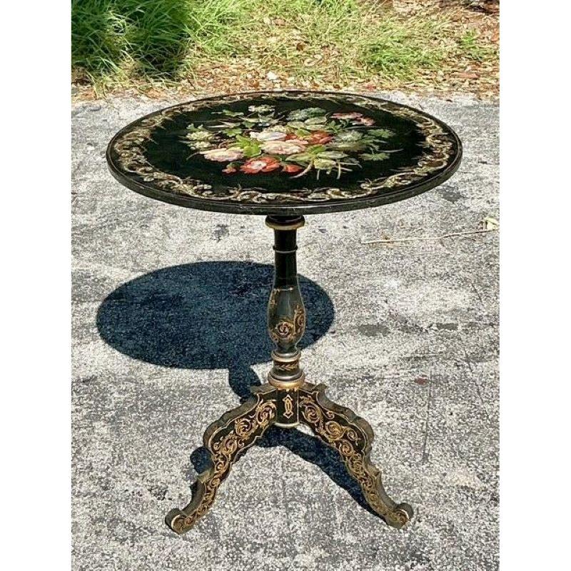 Experience the opulent artistry of the Victorian era with this magnificent antique side table. A true masterpiece of craftsmanship, the table features a lustrous black lacquer surface that serves as a dramatic canvas for an intricate floral bouquet.