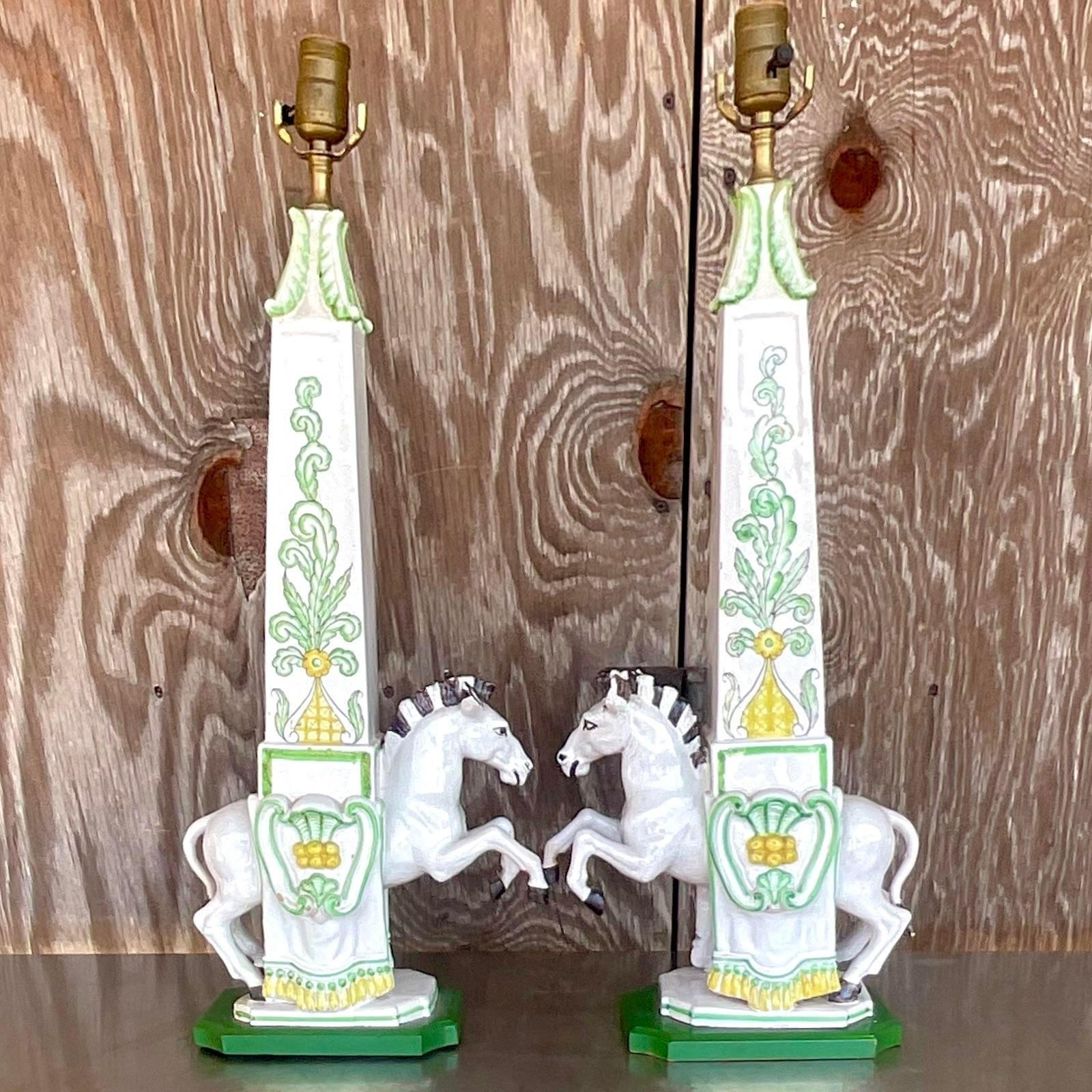 A fabulous pair of vintage Italian Regency table lamps. A charming pair of prancing zebras in an obelisk shaped frame. Hand painted detail in green and yellow. Acquired from a Palm Beach estate.