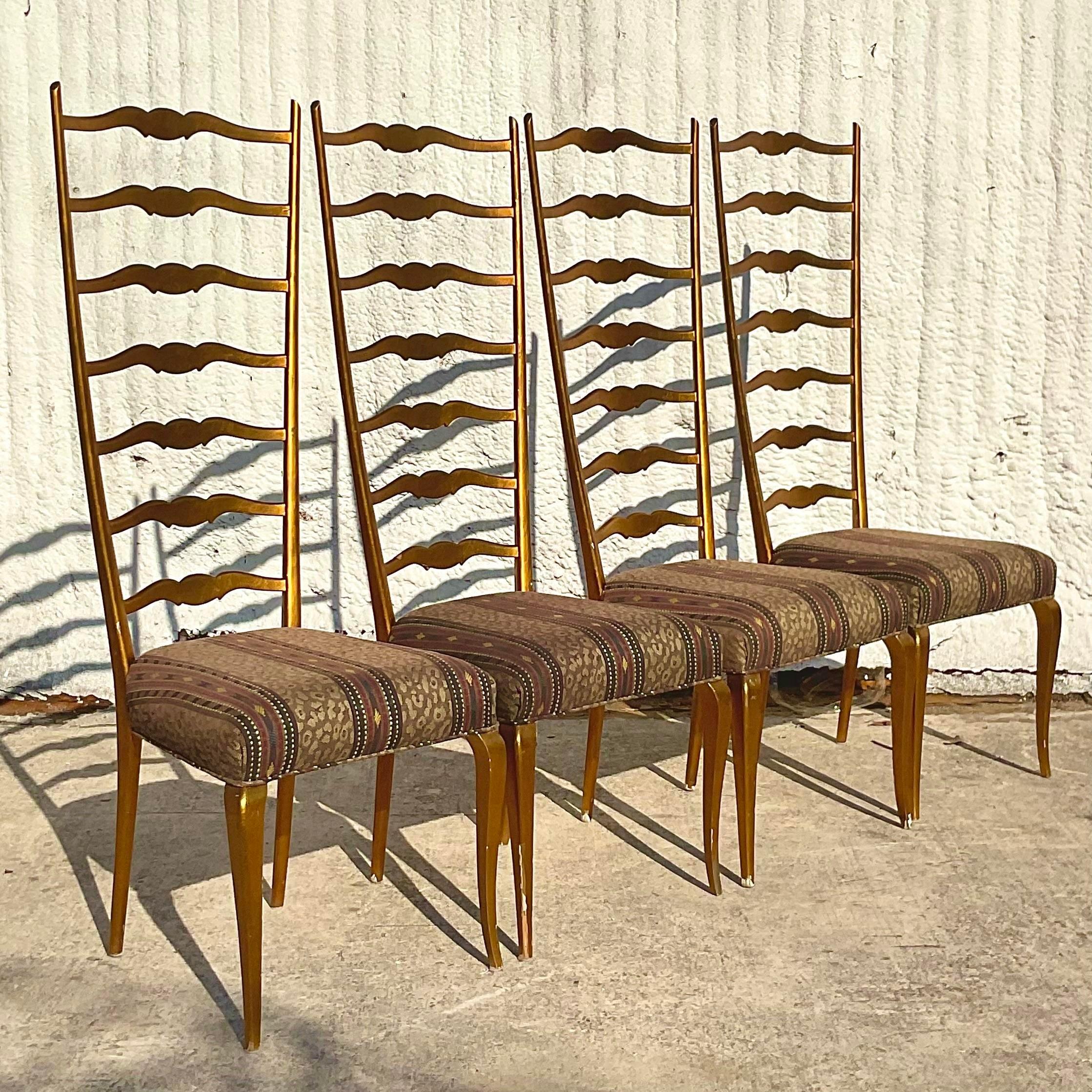 An exceptional set of four vintage Regency Italian dining chair. Beautiful gilt finish on a chic ladder back design. A tall and impressive profile. Acquired from a Palm Beach estate.
