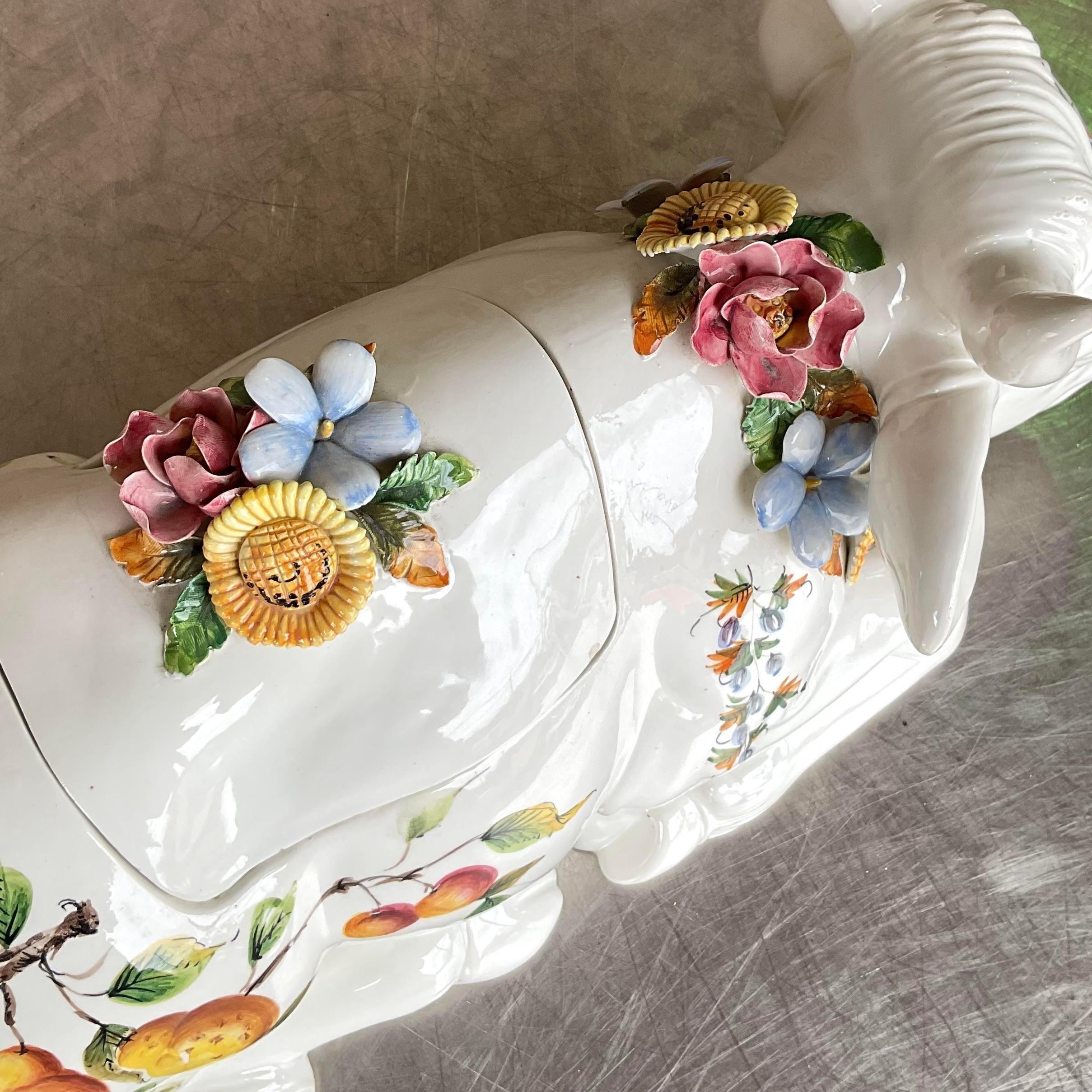 Bringen Sie einen Hauch von Eleganz und Skurrilität auf Ihren Tisch mit dieser italienischen Bullenterrine im Regency-Stil mit Blumen. Diese Terrine ist mit lebhaften Blumenmustern und aufwändigen Details kunstvoll gestaltet und verbindet