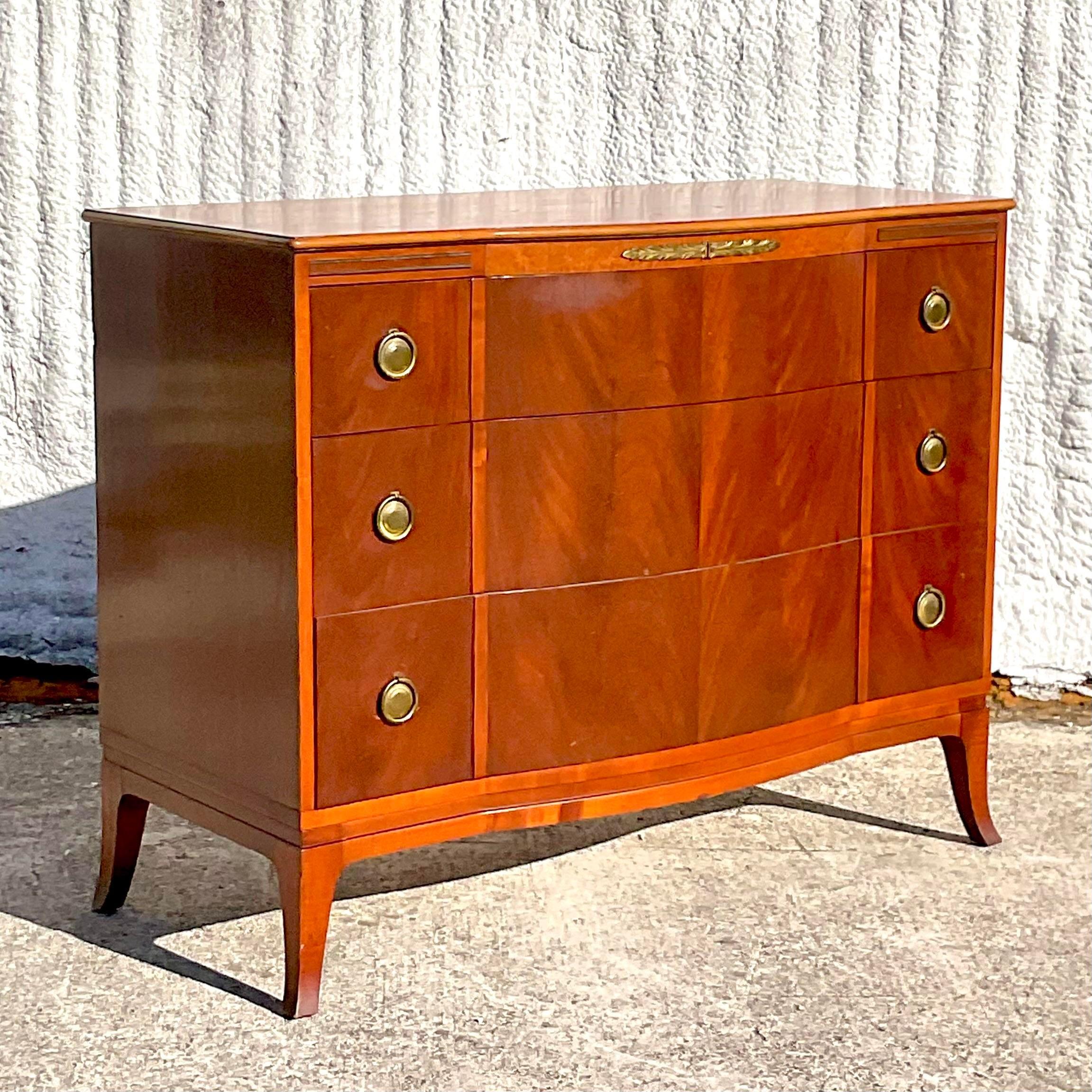 A stunning vintage Regency chest of drawers. Made by the iconic John Stuart group. Beautiful flame Mahogany with brass laurel detail. Signed on the inside. Perfect as a chest, sideboard or entry console. You decide! Acquired from a Palm Beach estate.