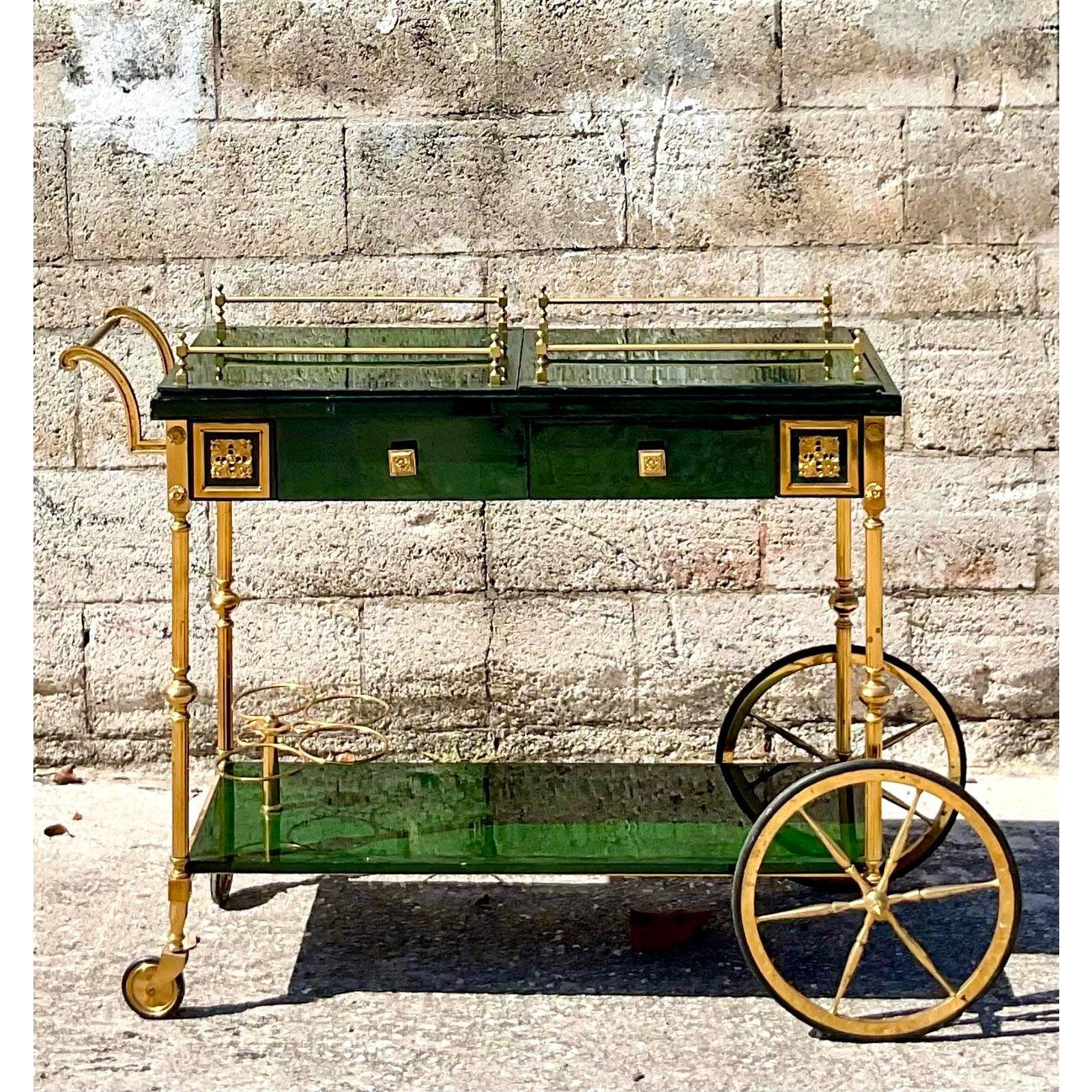 Incredible vintage Regency bar cart. Done in the manner of the iconic Aldo Tura. Beautiful deep green finish with turned brass hardware. Acquired from a Palm beach estate.