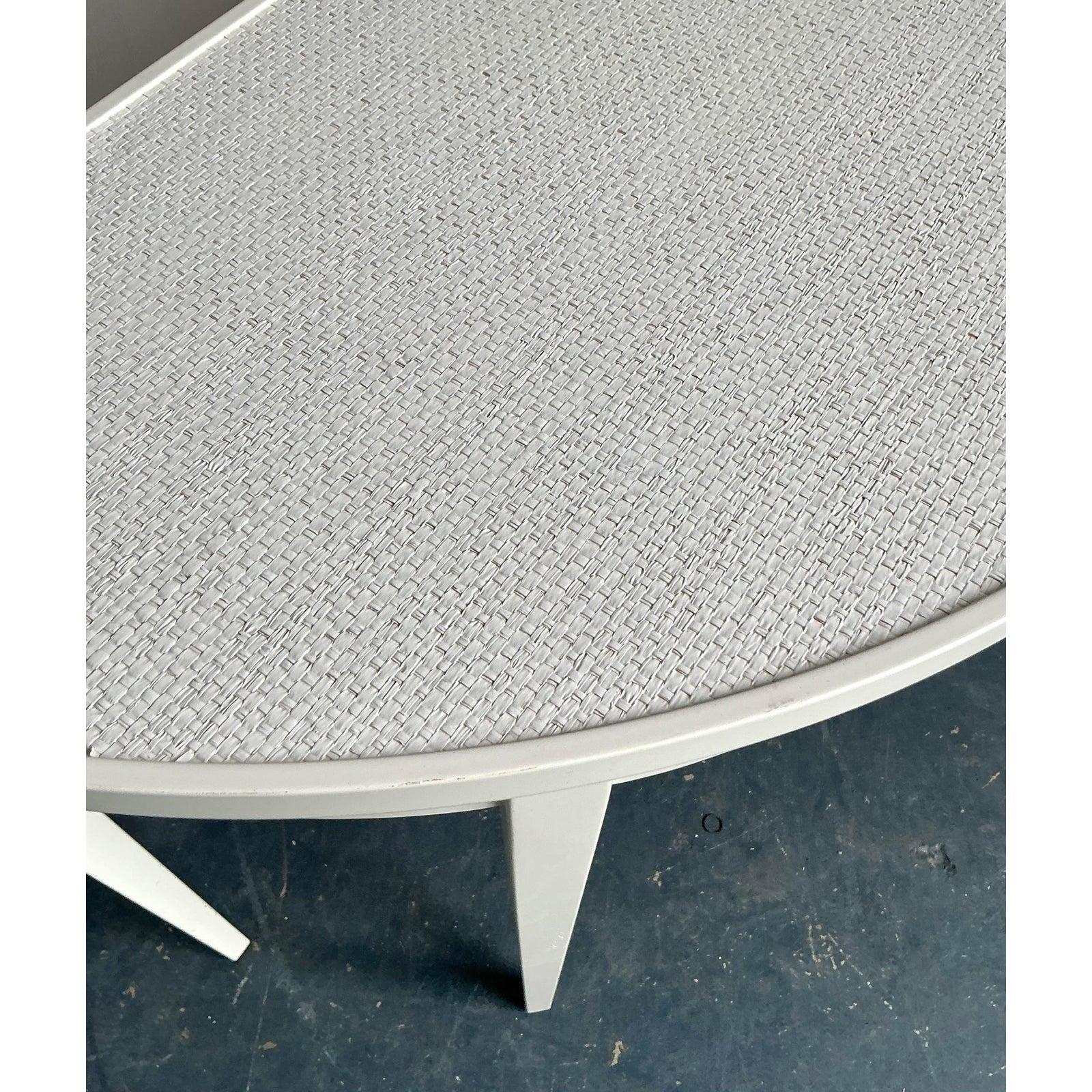 Presentamos una elegante mesa demiluna vintage de estilo Regencia, exquisitamente acabada en un impoluto lacado blanco con un exclusivo tablero de tela de hierba. Esta pieza captura la refinada estética de la época de la Regencia, al tiempo que